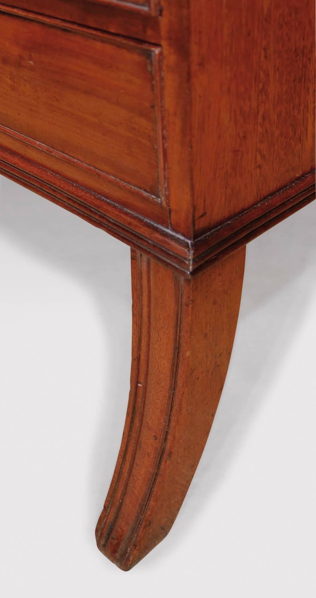 An early 19th century Regency period mahogany waterfall bookshelf, having shaped sides and open shelves above four cockbeaded drawers supported on sabre legs, circa 1820.