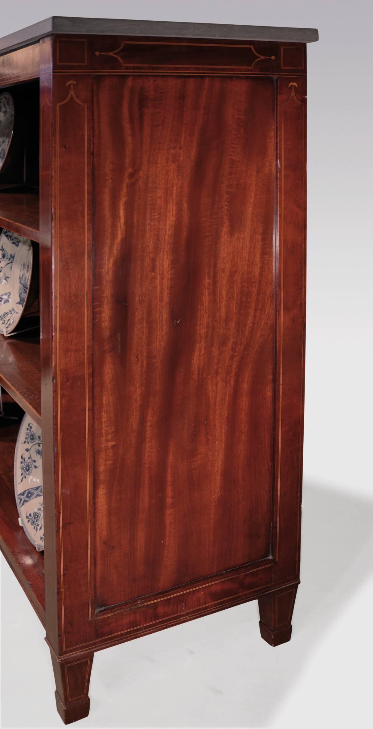 A pair of George III period mahogany open bookshelves, boxwood and ebony strung throughout, having rectangular marble tops, above narrow friezes, supported on square tapering legs and spade toes.