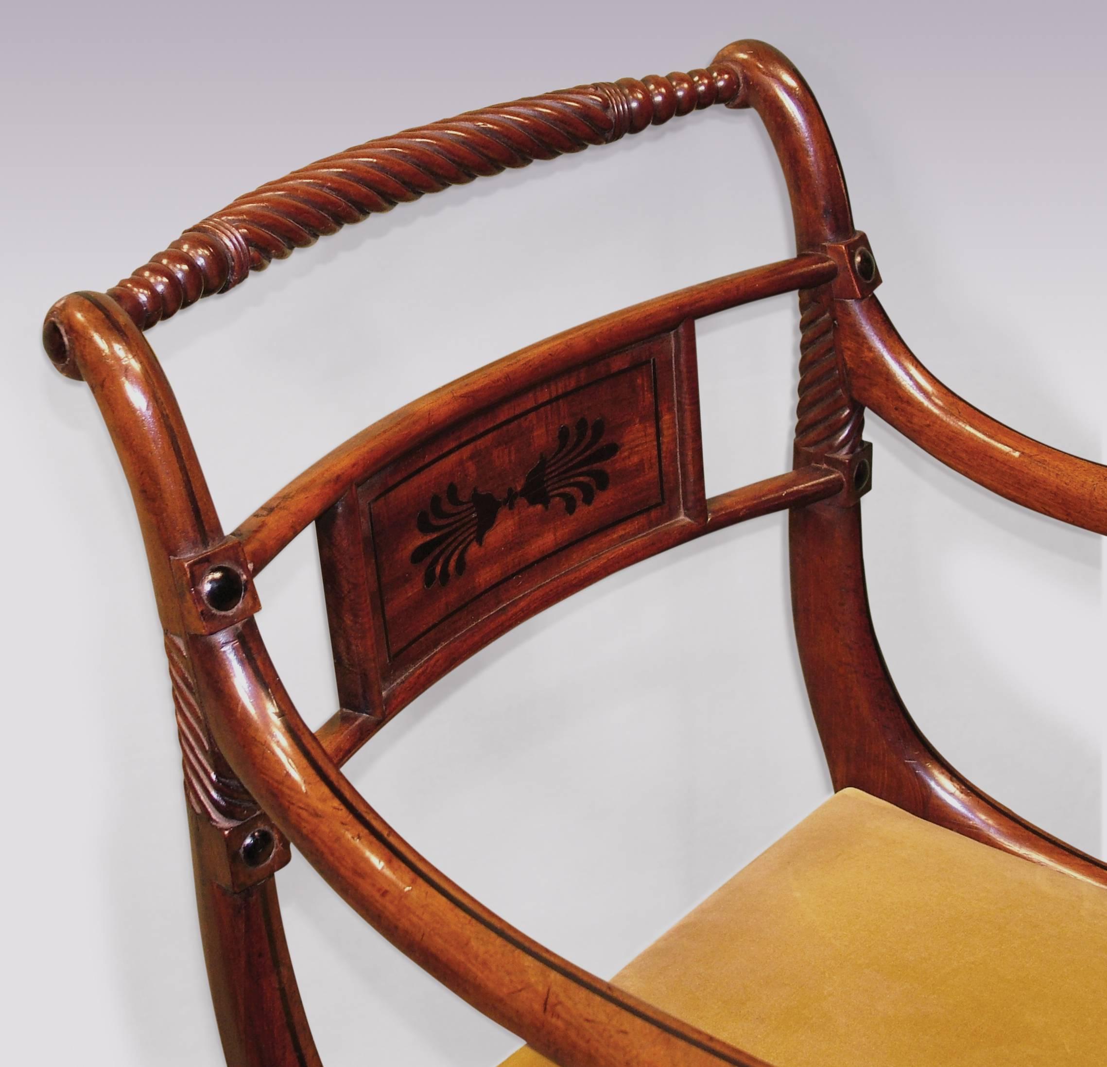 A fine quality pair Regency period mahogany rope-twist armchairs, ebony line inlaid throughout having anthemion inlaid panels to the backs above drop-in seats, supported on sabre legs.