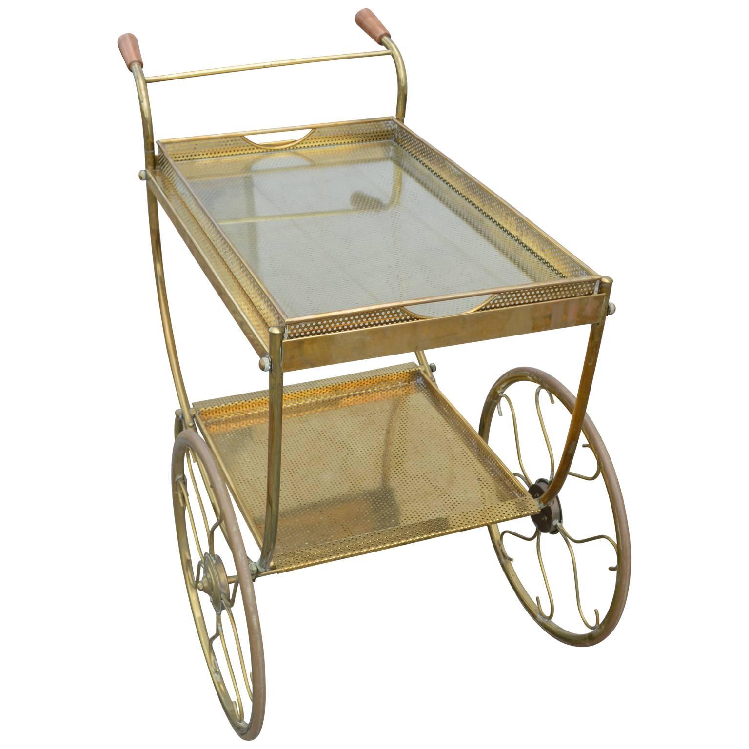 Italian two-tier bar cart with glass shelves and two oversized wheels. Charming and in good condition.