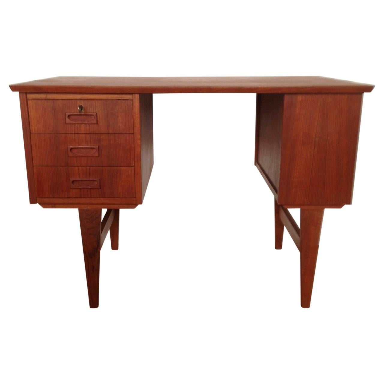 Lovely little Danish Mid-Century teak desk, with three drawers, one shelf on the side and one on the back.