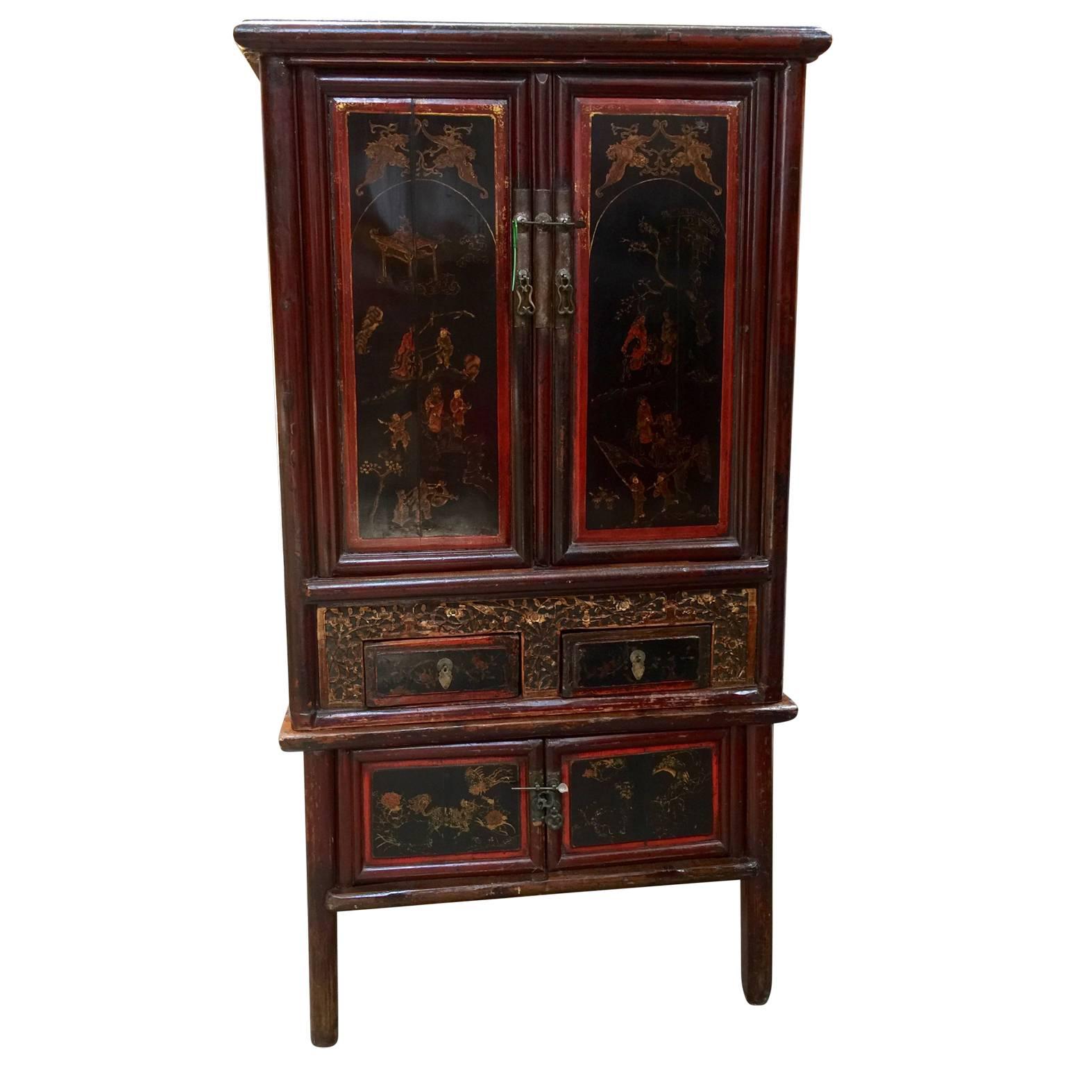 Beautiful Chinese cabinet in mainly black and red lacquer with red decorations. Contains several shelves and four drawers, all with original brass hardware.