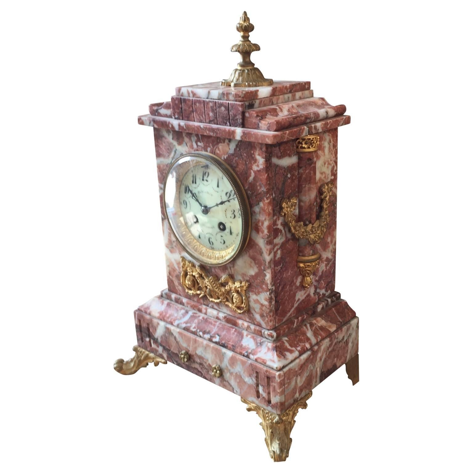 Red marble mantel clock mounted with ormolu hardware.