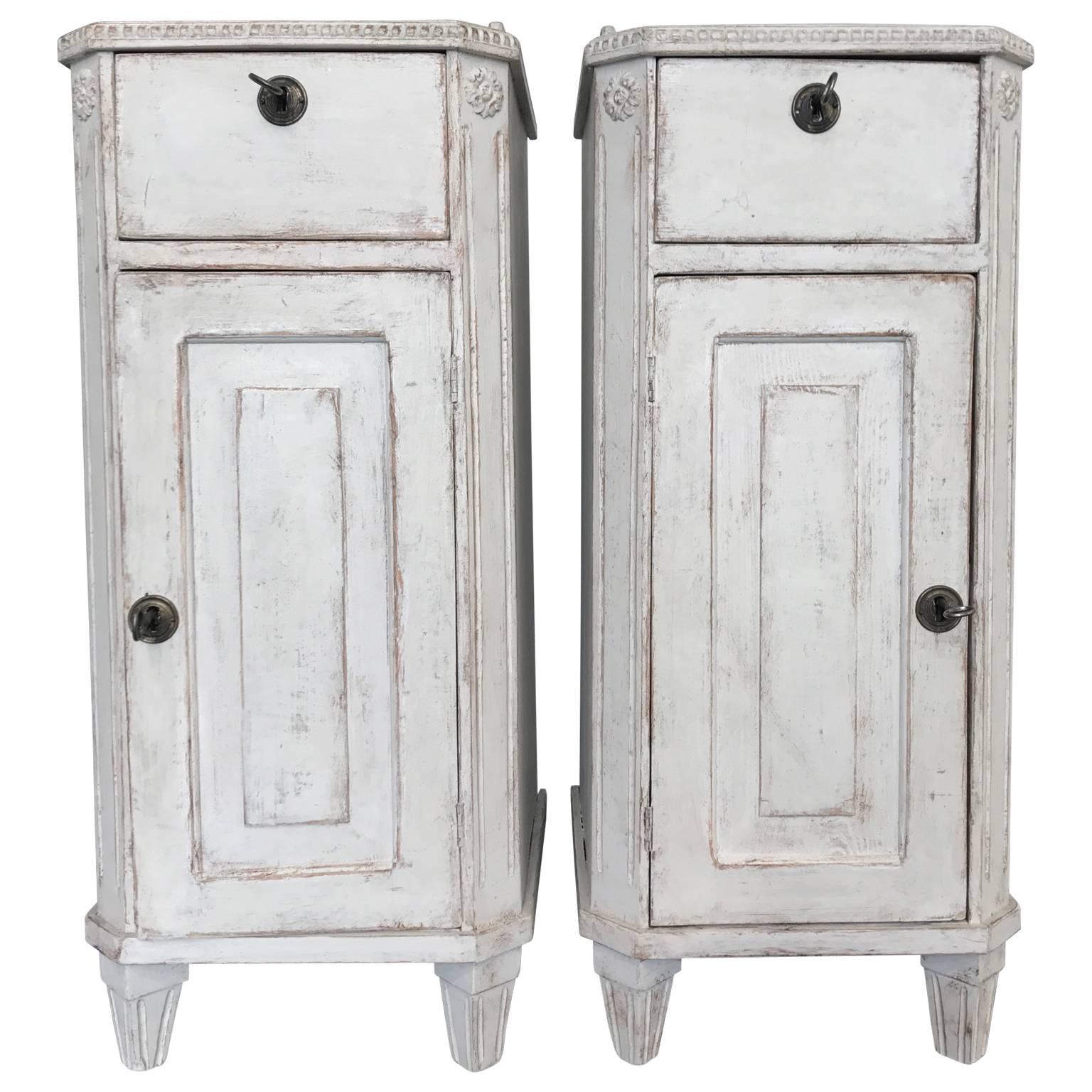 Early 19th century pair of white Gustavian nightstands. The side tables each has a drawer and a door access to the cabinet.