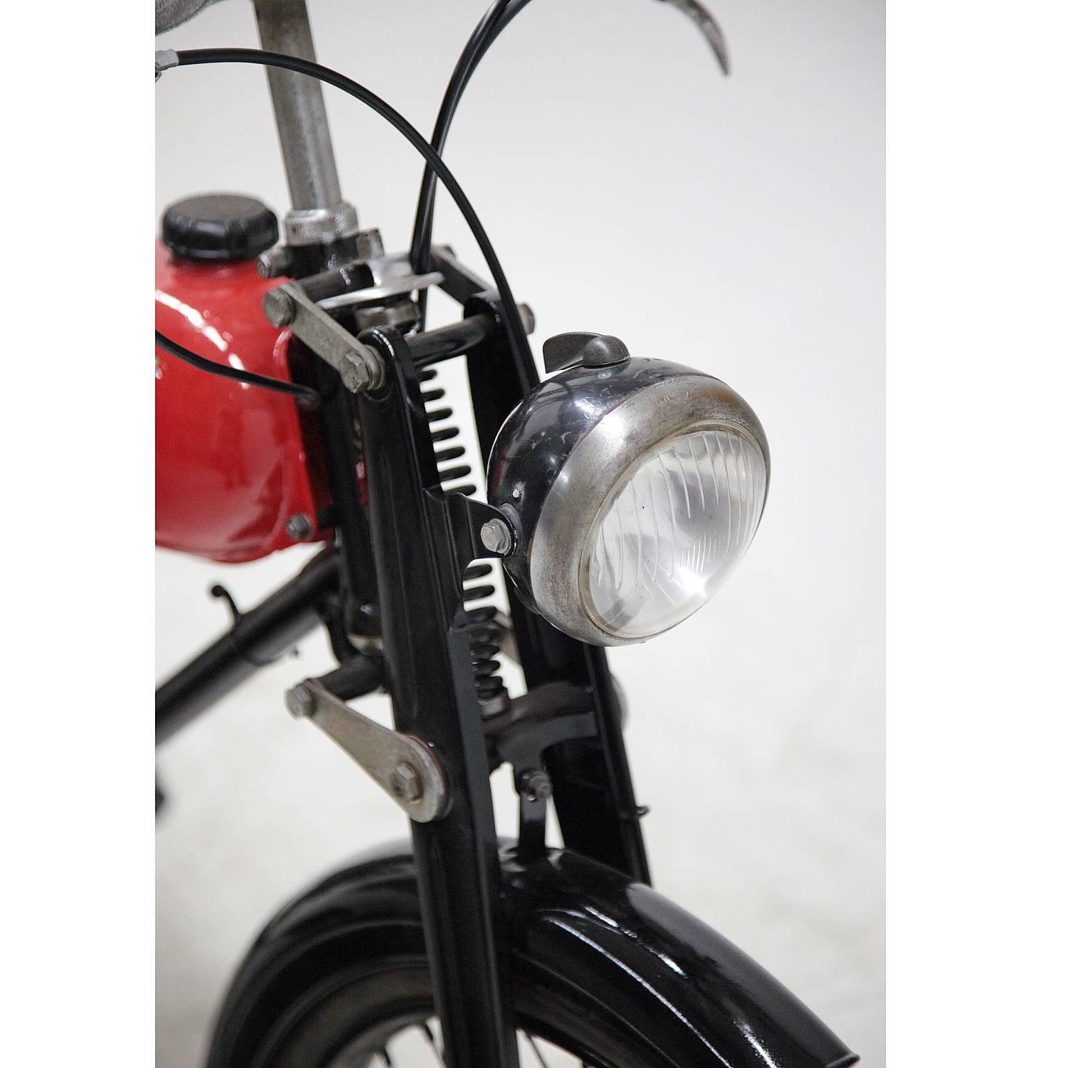 A very well kept moped from the famous Italian company Bianchi in Milan. The tank is red while the rest is completely black. There are Bianchi emblems on the handlebars, the fender and the chain guard.