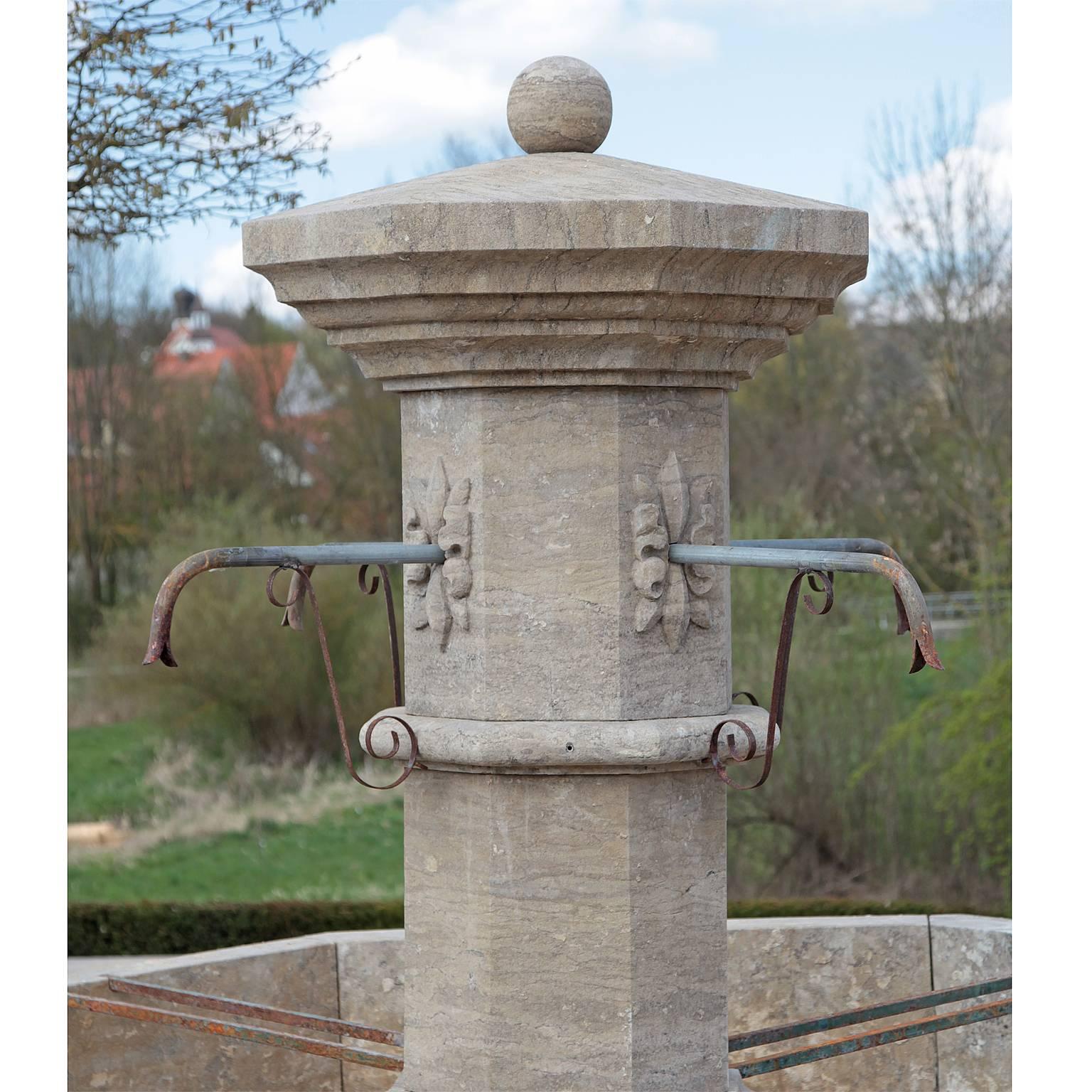 A fountain with a central risalit crowned with a ball and an octagonal, profiled rim. The water comes out of four metal spigots, which project out of flower ornamentations. The height of the rim is 62cm. The fountain is finished with hand-worked