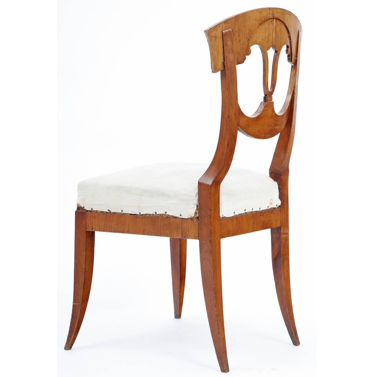 A collection of six classical chairs on legs which flare slightly outwards. The open-work backrests of the chairs are decorated with noble wood inlays and wood-burned accents.

        