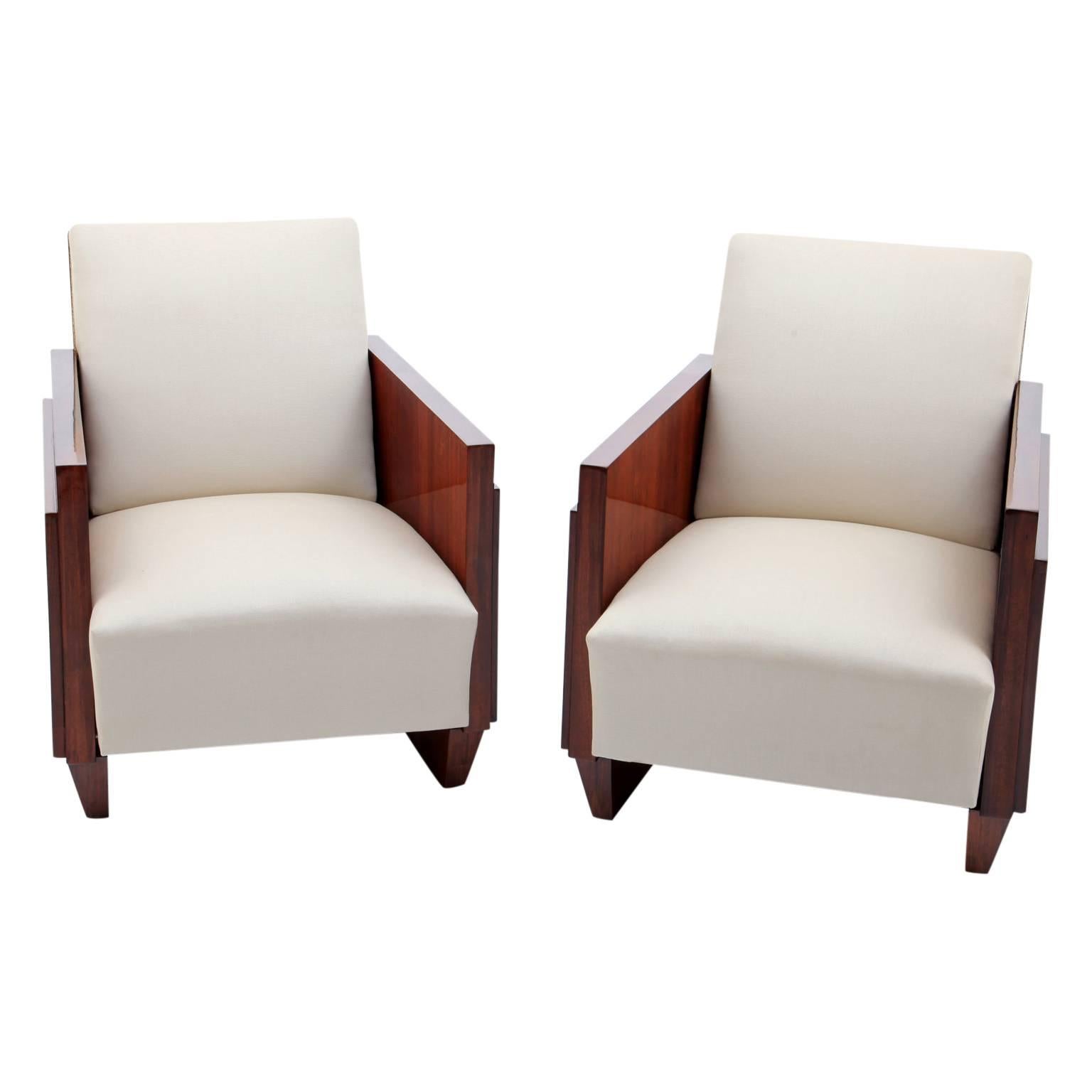 Pair of Art Deco lounge chairs in the style of Andre Sornay with rectangular armrests and thickly upholstered seat and backrest.