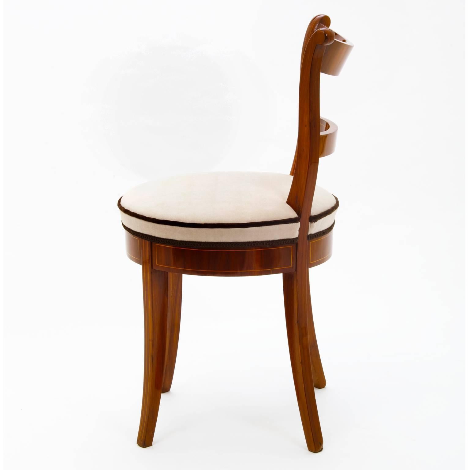 Four delightful lady chairs made out of plum wood, with a round seat and slightly flared legs. The backrest is curved and decorated with fine maple thread inlays. The seats are newly upholstered.
