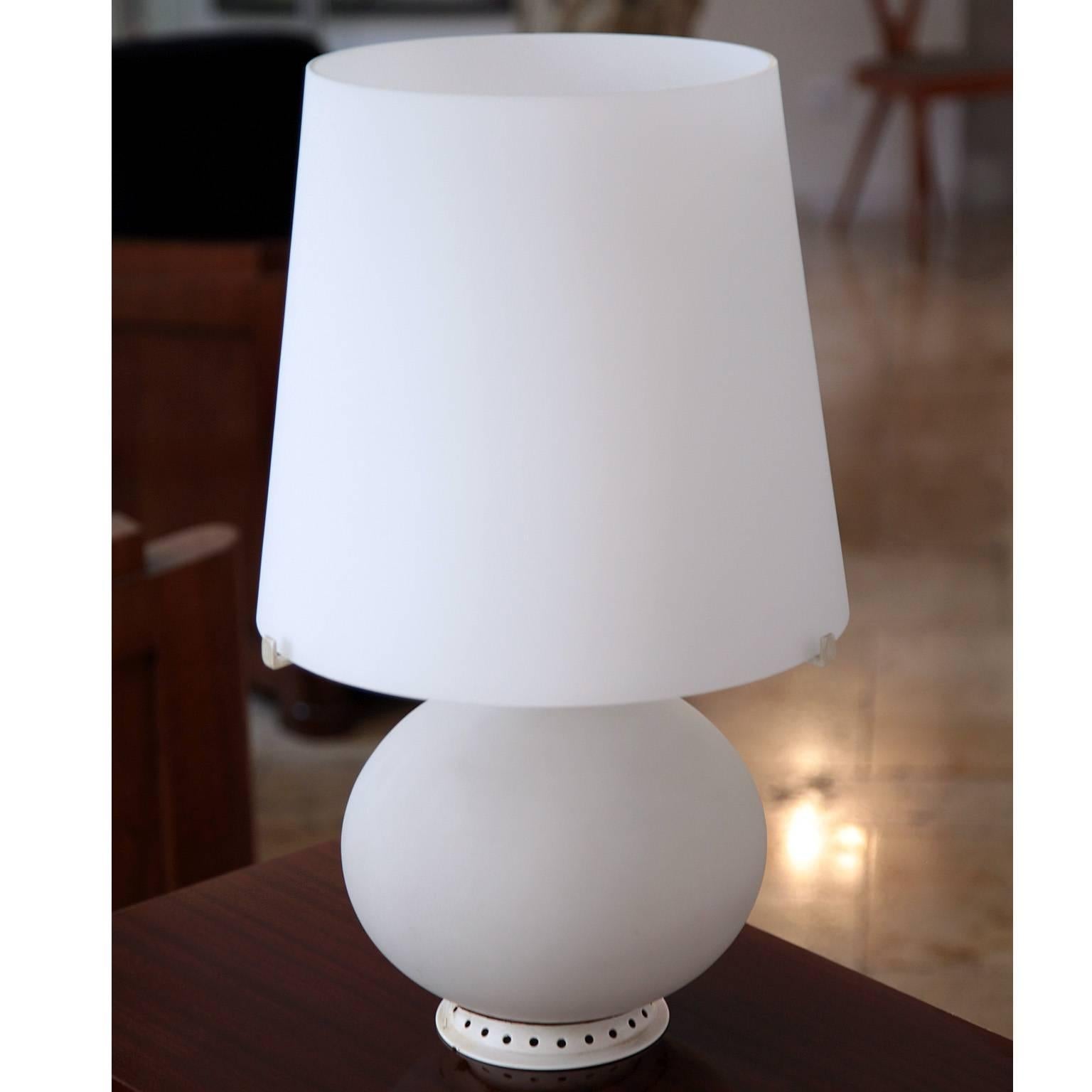 Fontana 1853/1 lamp by Max Ingrand designed for Fontana Arte in 1954. The lamp stands on a round metal stand with hole structure. The body and lampshade is opaque glass. This is the middle sized type.

For the electrification we assume no liability