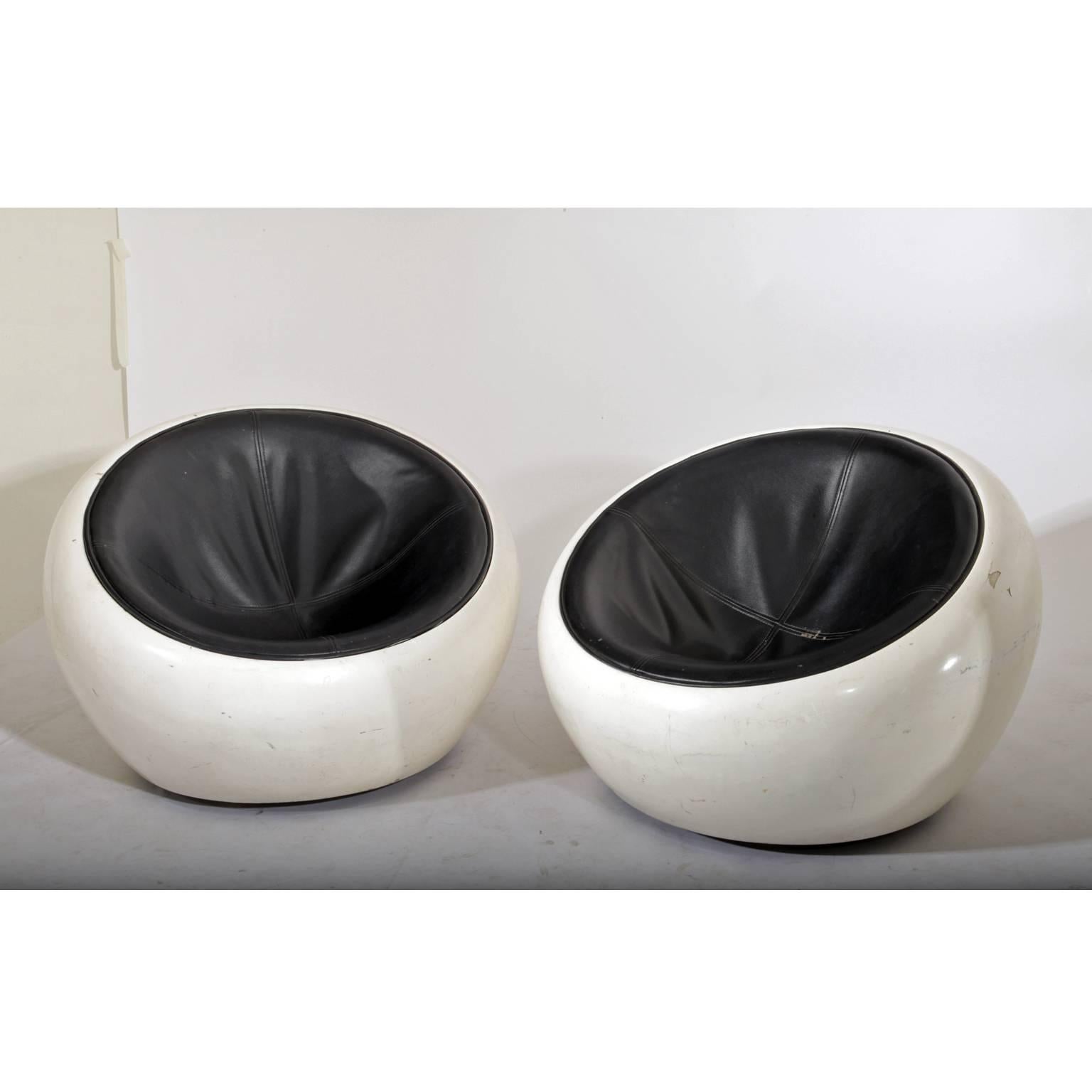 Pair of Half Dome chairs by Finnish designer Eero Aarnio. White fibre glass body and black leather upholstery. The condition of the body is consistent with age and use, has one chip on the side, the leather is in a good condition.