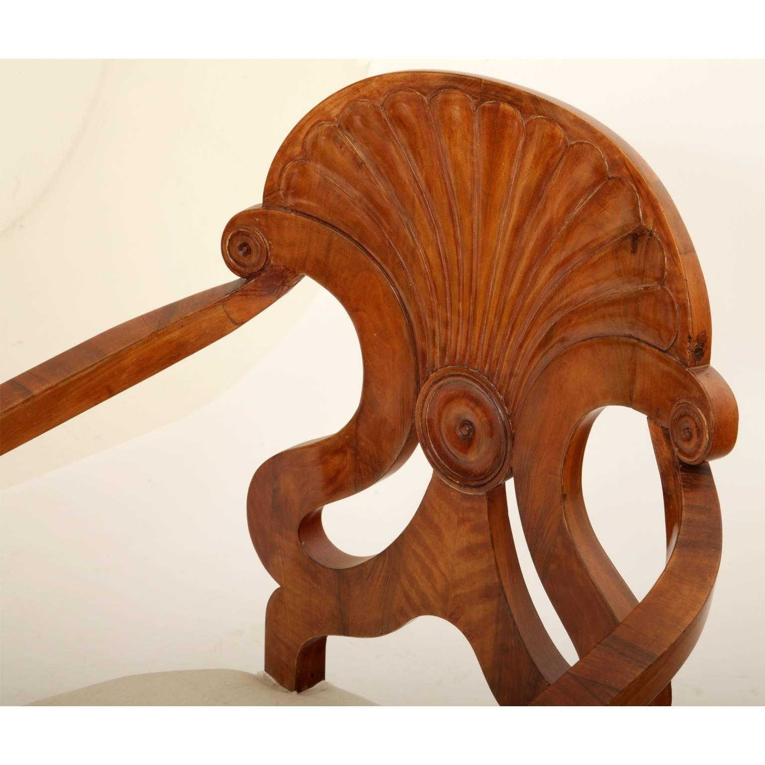 Pair of Biedermeier bergère chairs with a fan-shaped carved backrest and tapered feet.