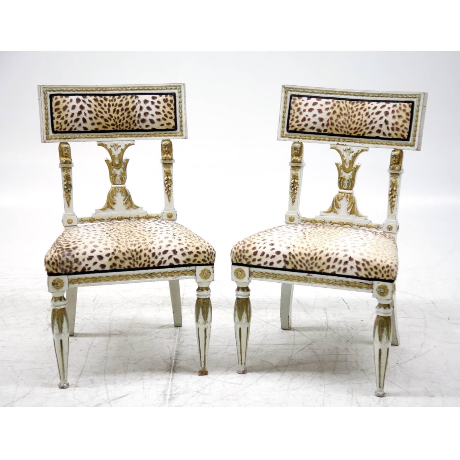 Pair of white dining chairs in Gustavian Style with gold details. In an unrestored condition.