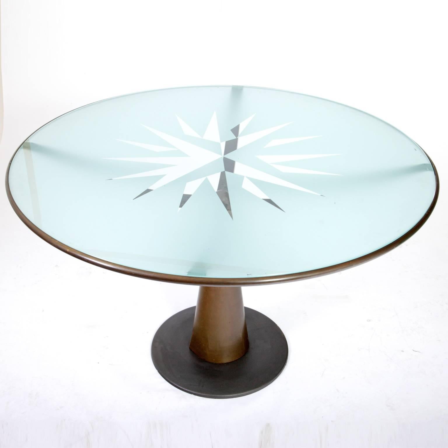 Round table by the Catalan designer Oscar Tusquets for Aleph. The Stand is made out of bronze, the glass top is matted, except for the star-shape in its centre. The table is signed "Aleph by Tusquets". The bronze has small cracks at the