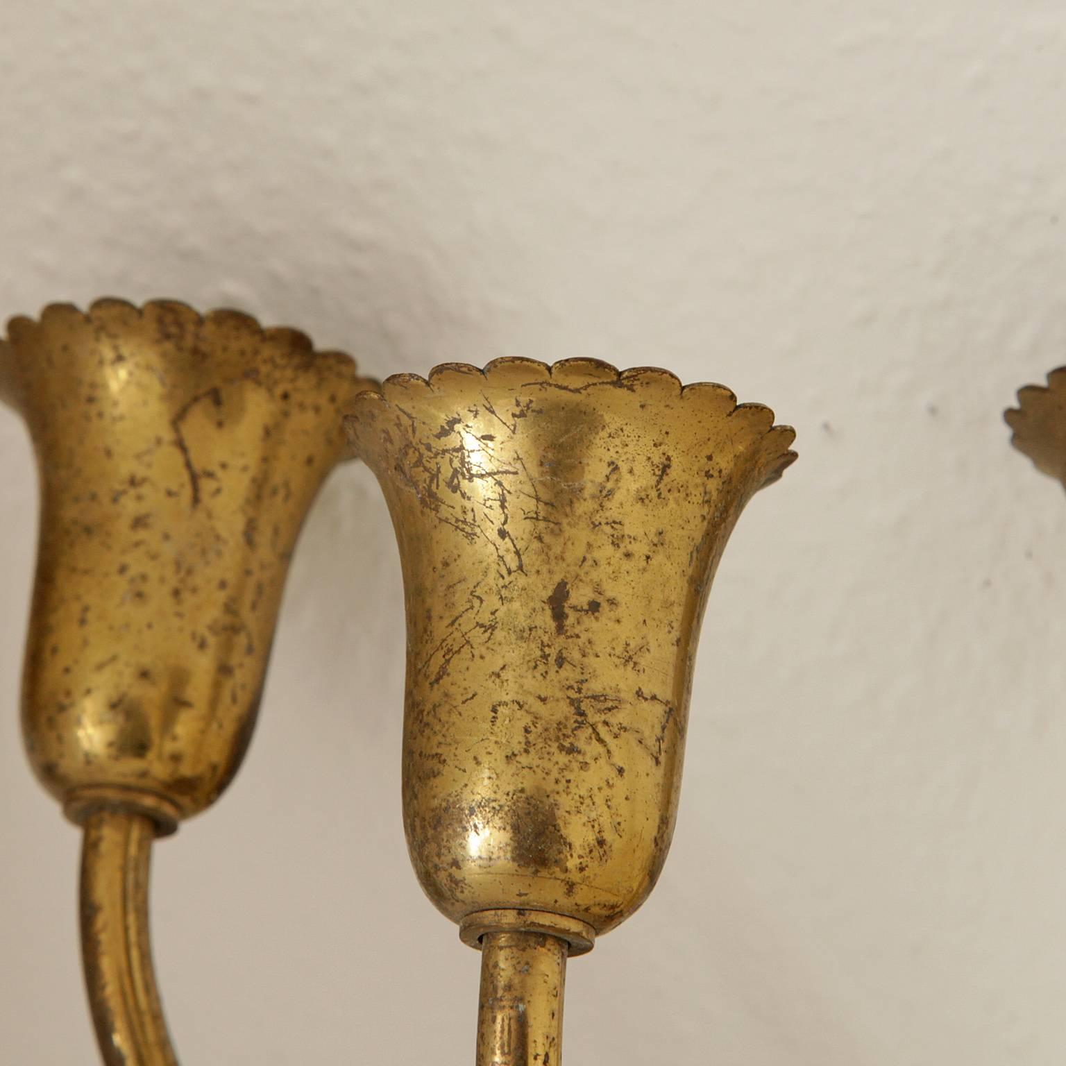 Pair of brass sconces with three arms each in the shape of stylized tulips.