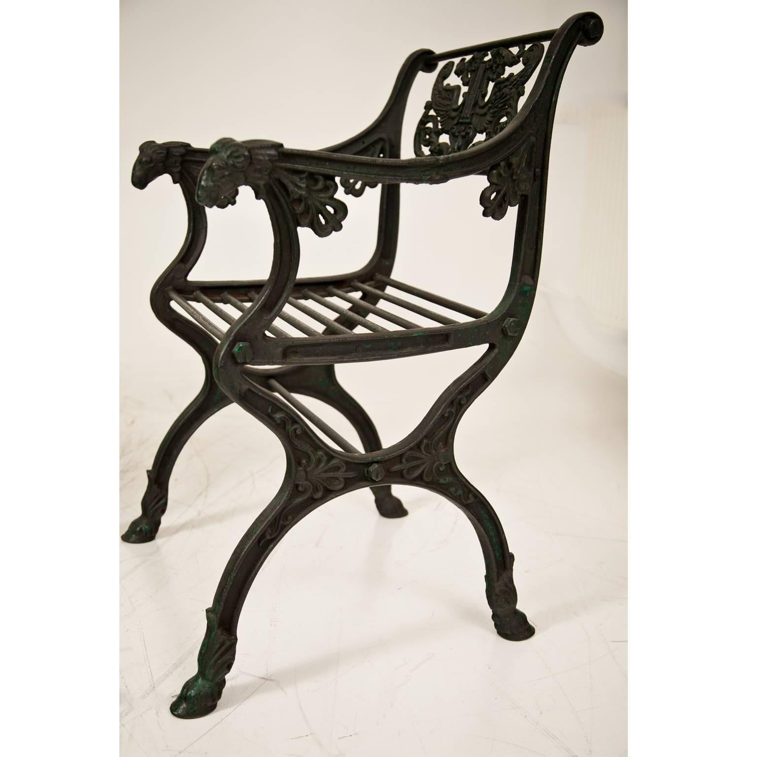 Pair of cast iron garden chair after a design by Karl Friedrich Schinkel (1781-1841) for the Roman Baths in Potsdam. The design is probably from circa 1830. The chairs show goat's feet and ram's heads. The backrest is decorated with a lyra, carried