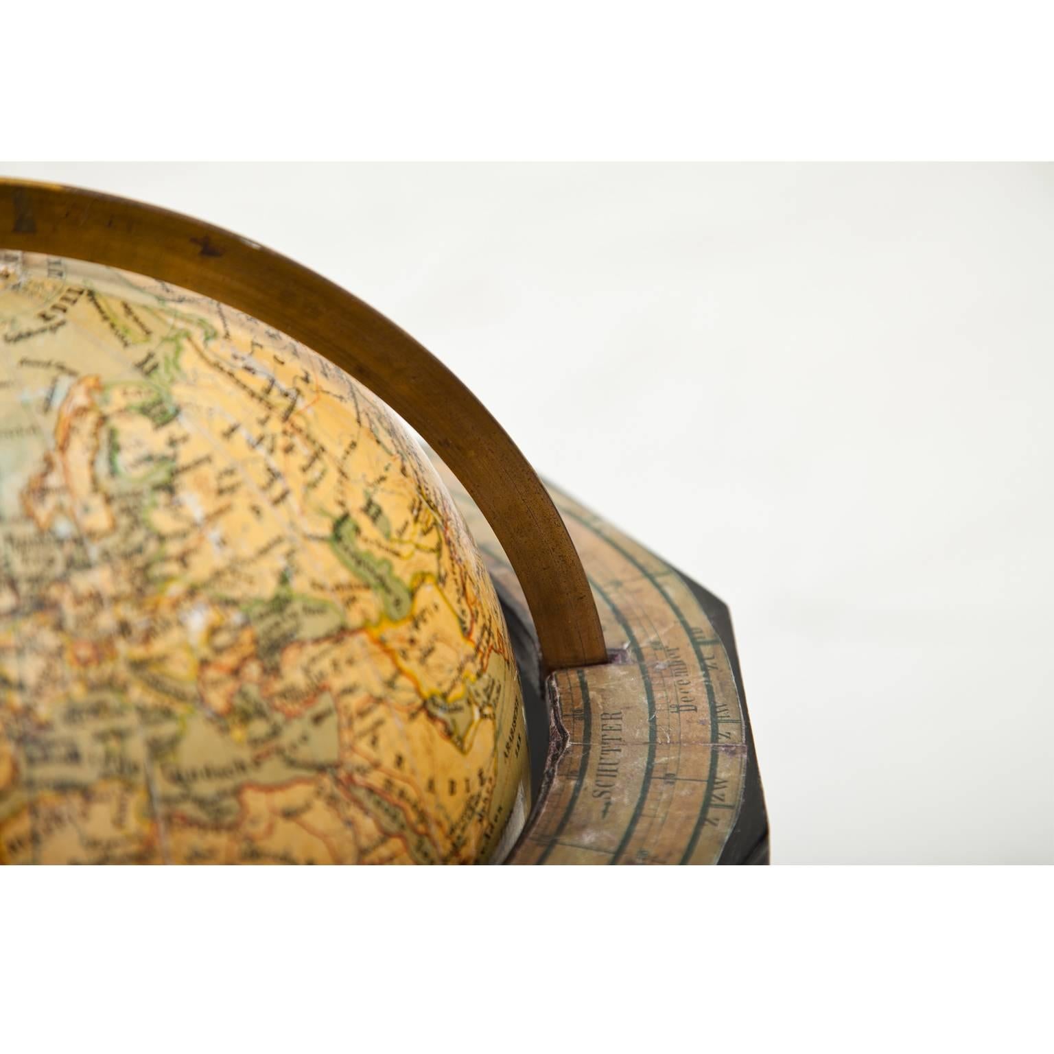 Globe with brass meridian and horizon ring with zodiac signs on a tripod base. The globe is made out of papier mâché and in Dutch. Marked 