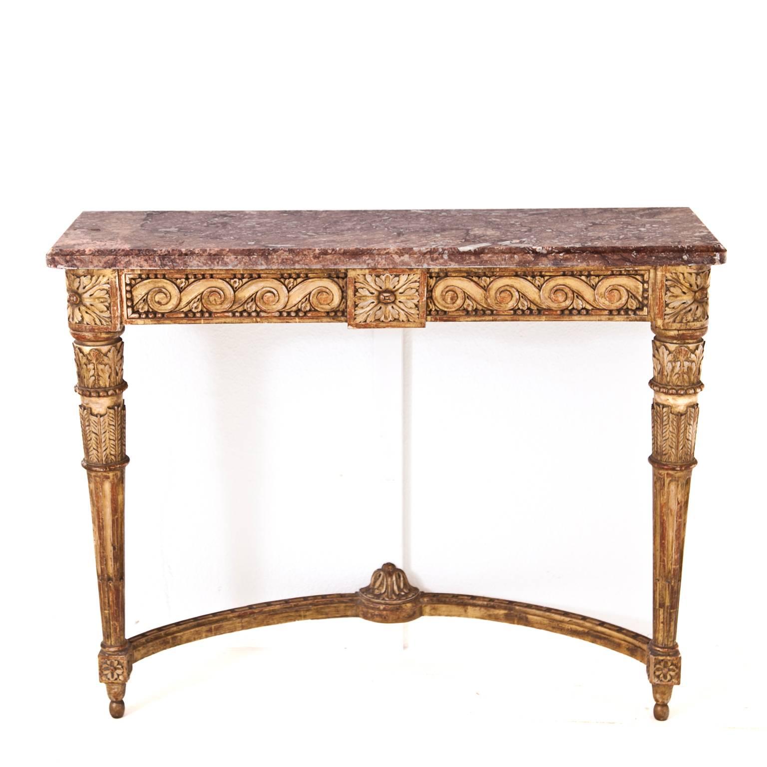 Louis-Seize console table with red marble top on gilt fluted legs. On the front running scrolls ornament framed with pearls. The console's depth was changed in the 19th century.