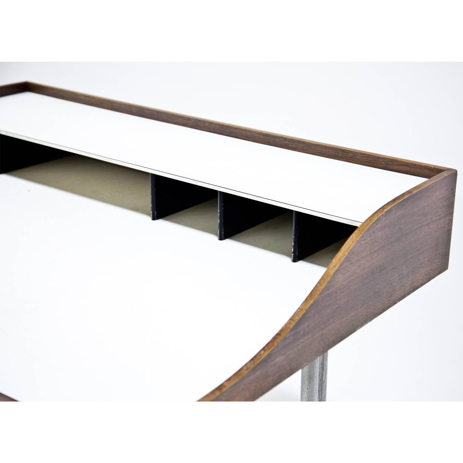 The famous 'Swag-Leg' desk by George Nelson, designed in 1954 for Hermann Miller. The iconic legs are metal, the dividers are in a dark brown color. Both drawers have the plastic inlays. The table shows wear consistent with age and use. The table is