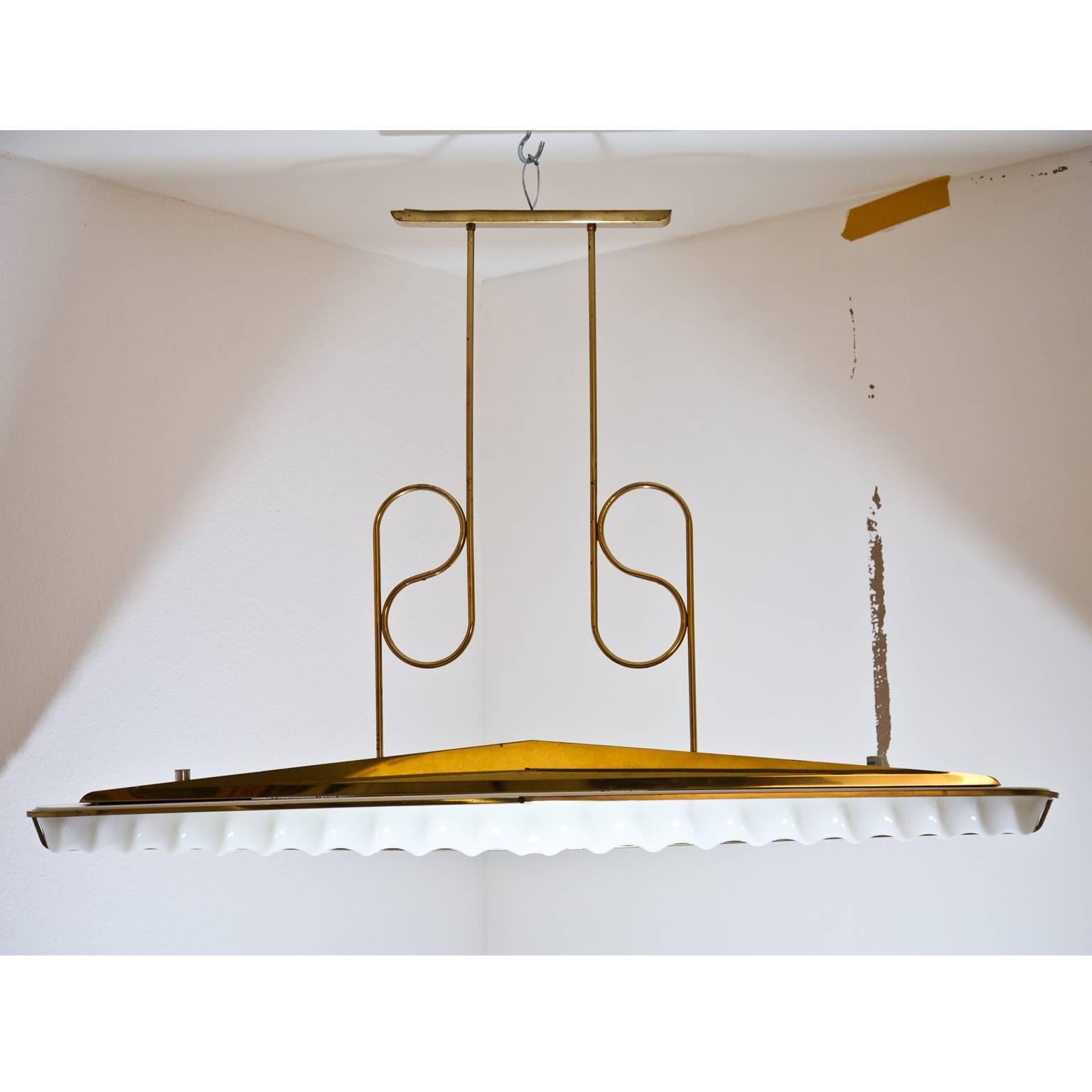 Large ceiling light with a pediment shaped body and S-shaped poles. The wavy lampshade is out of opaque glass. The long but narrow shape of the lamp makes it ideal for lighting dining room tables.