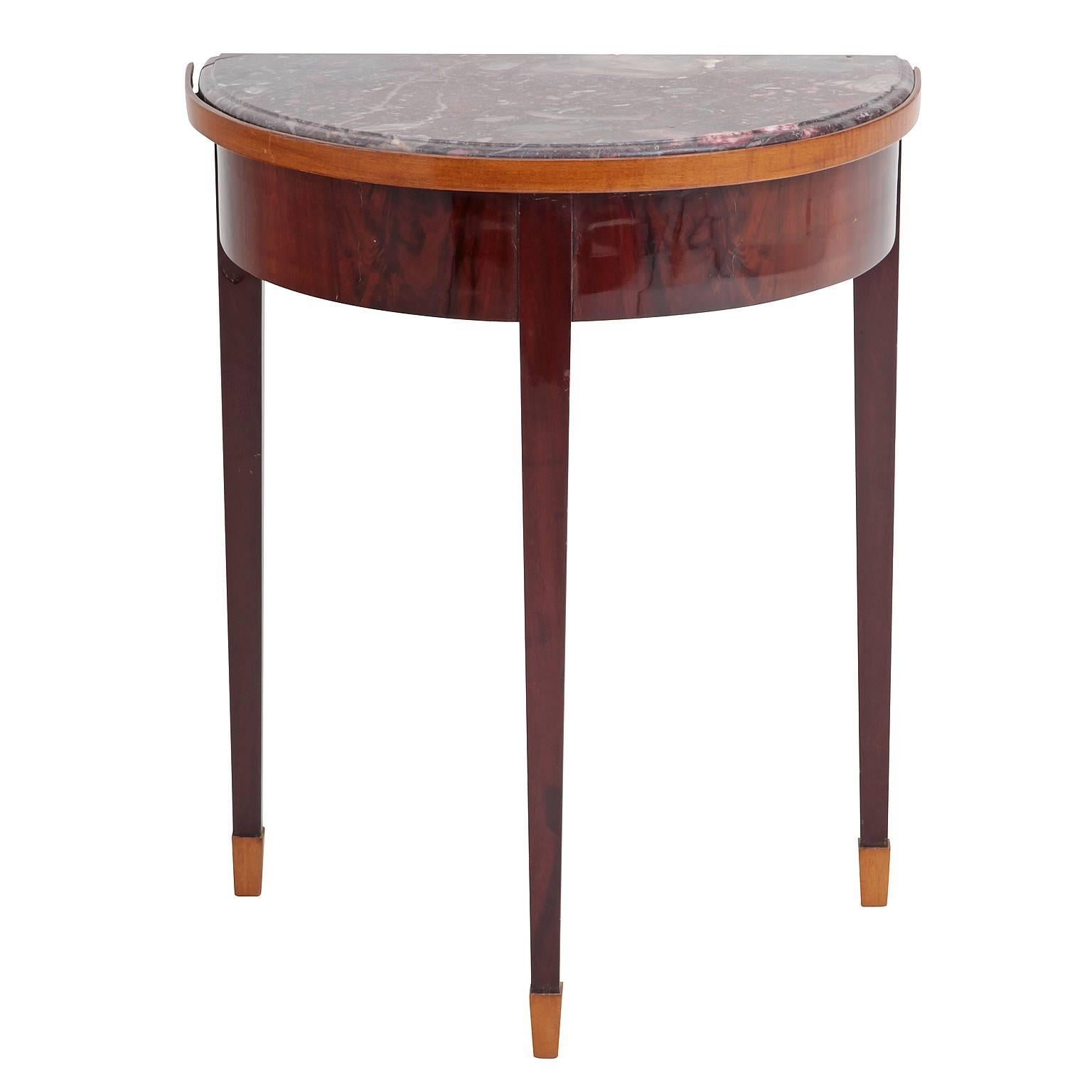 This console stands on three tapered square feet and has a gorgeous red and white grained marble surface. The edge and feet are accented with lighter woods.