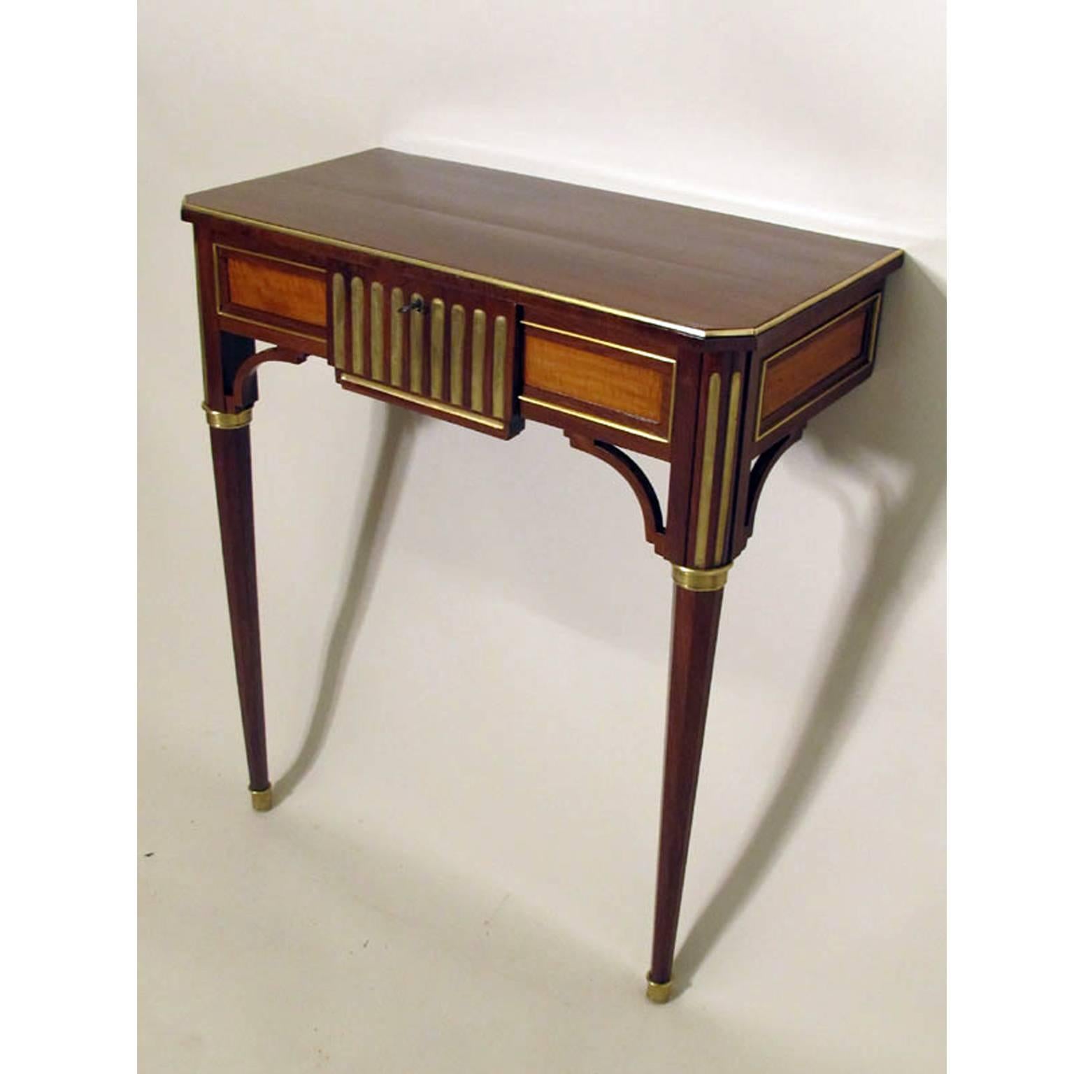 Empire console table with slanted corners on octagonal tapered feet with brass sabots and capitals. The coffered frame with one narrow drawer and brass accents.
