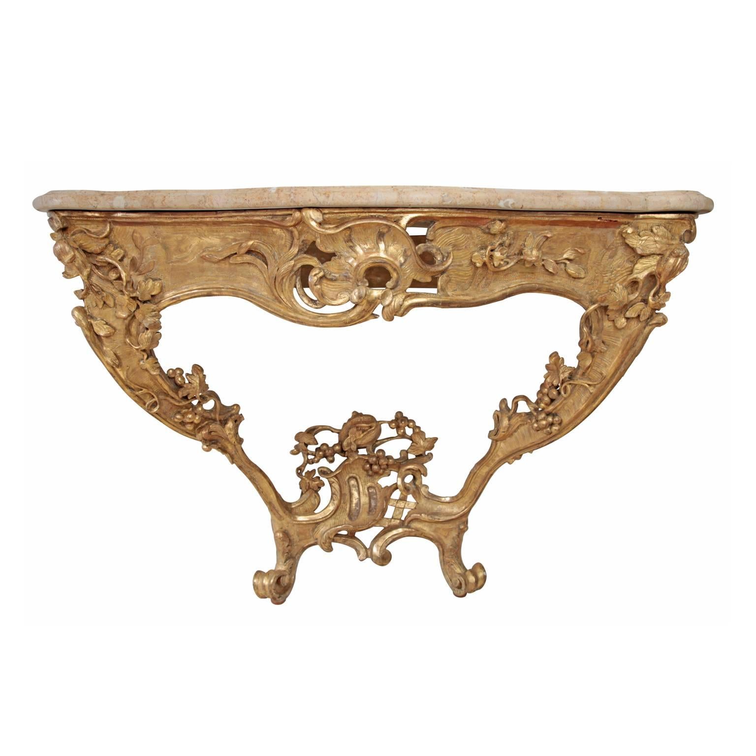 Exceptional Rococo console table with rosé-colored marble top. The asymmetrical giltwood base is decorated with rocaille, fruit and leaves decor.