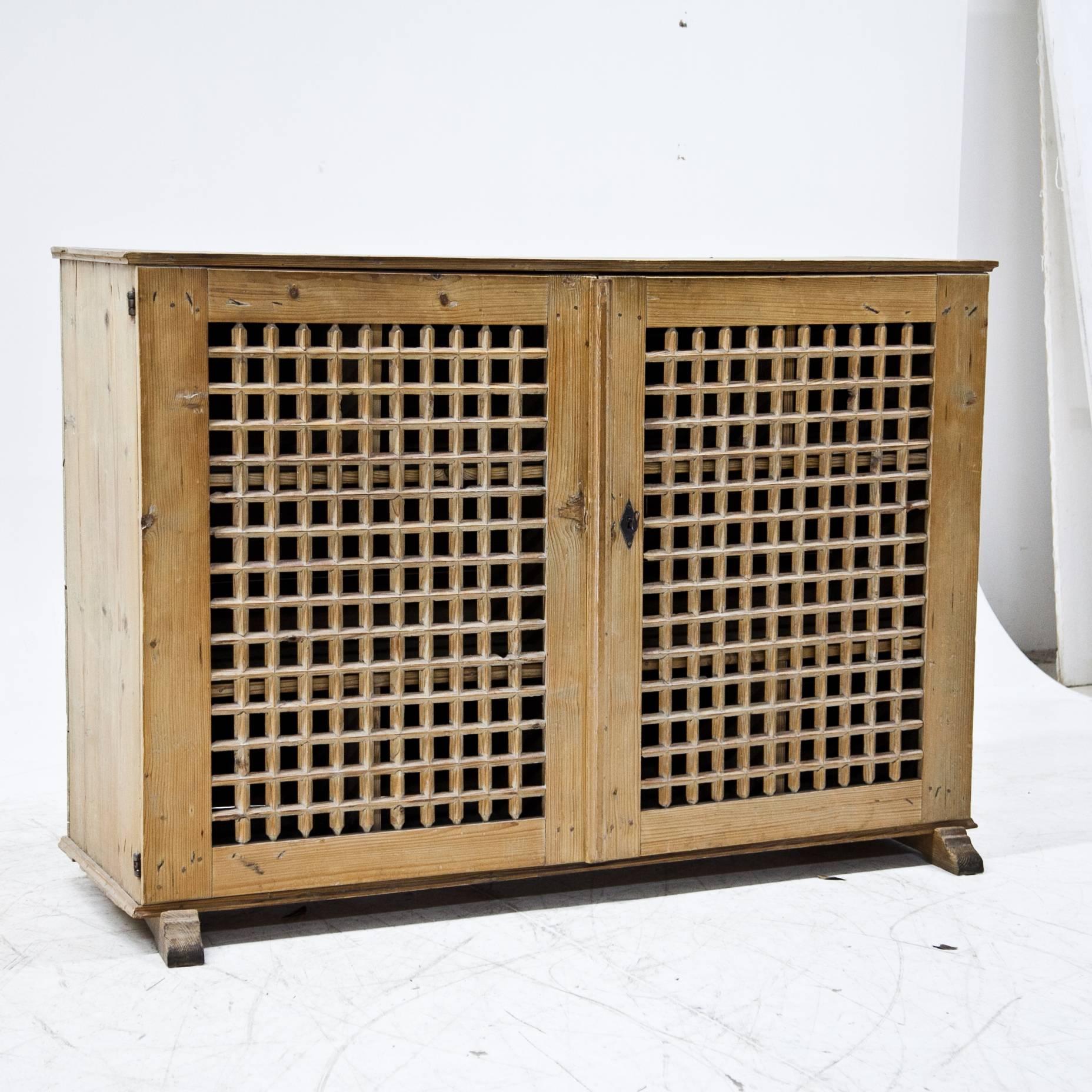 Two-doored wine rack with bars structure, out of natural pinewood with iron fittings. The legs were replaced.