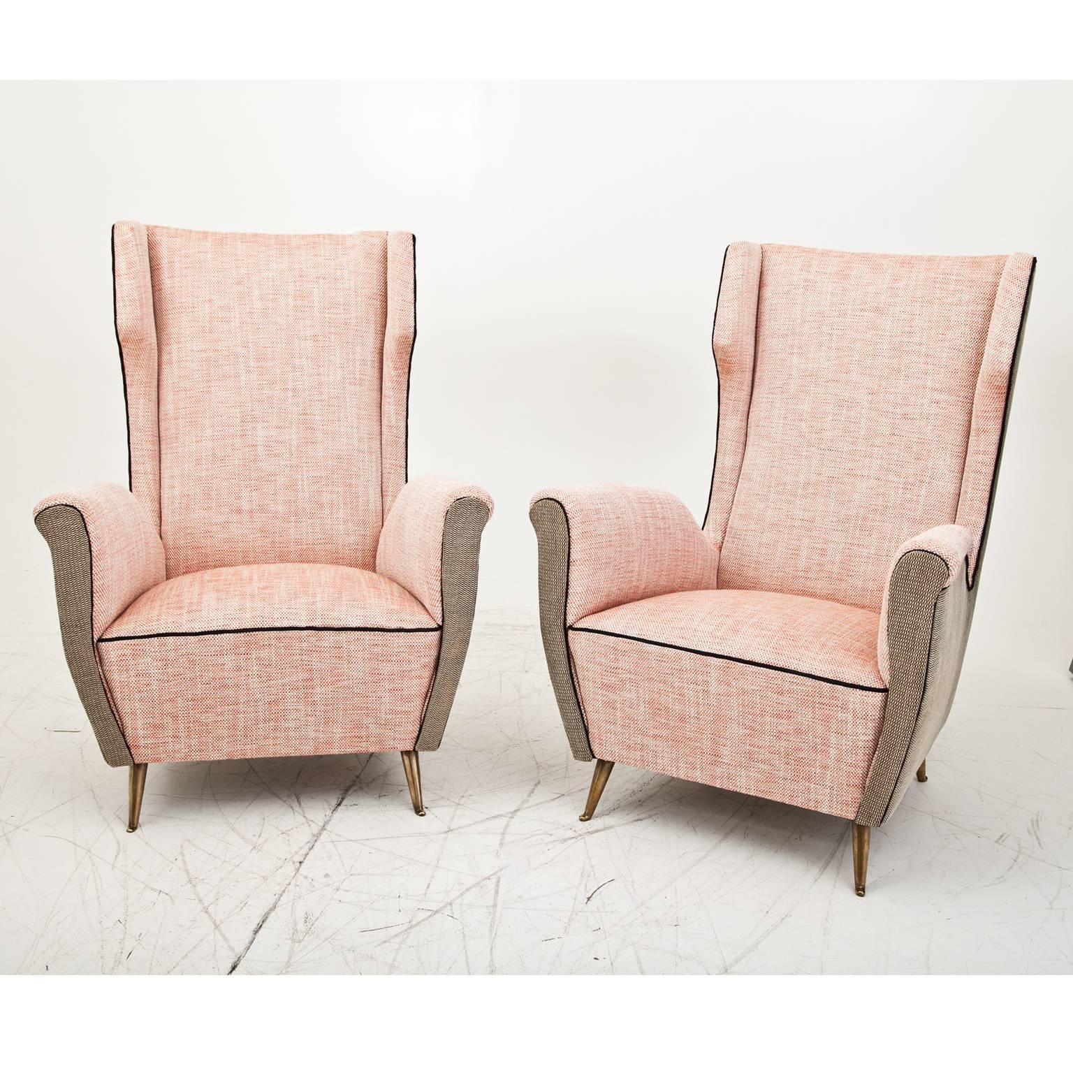 Pair of armchairs on brass feet with high backrests and slightly curved armrests. The chairs are reupholstered with a new, high quality fabric.