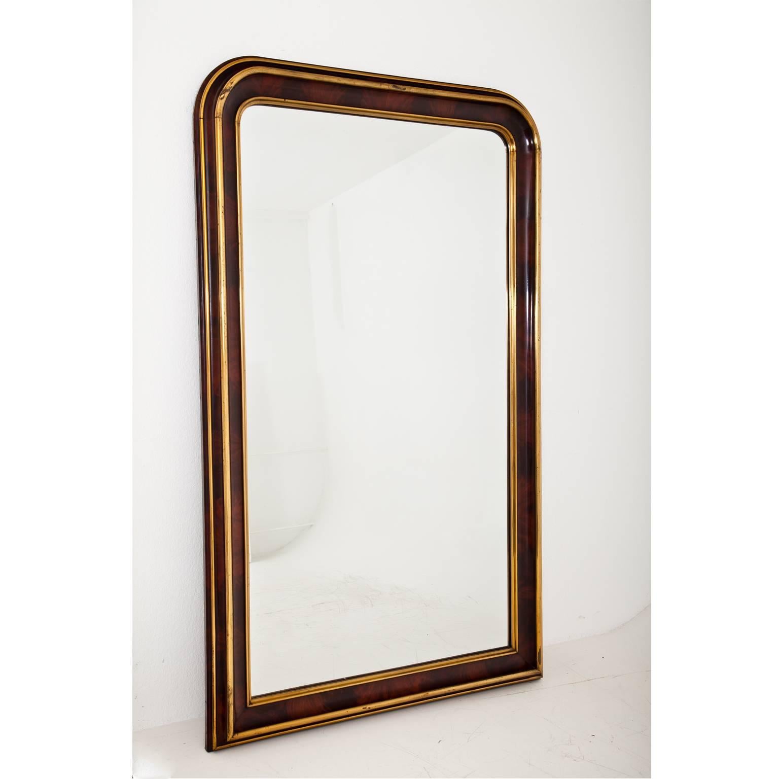 Large Louis Philippe wall mirror with a rounded top part and fire gilt brass mouldings. Old inventory label at the back 