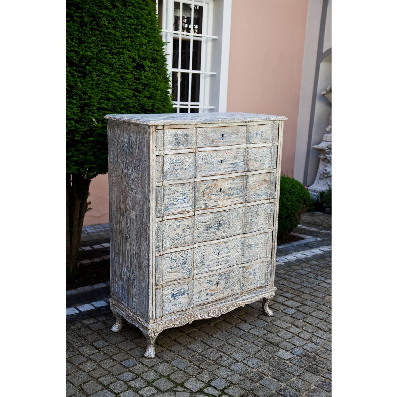 Six-drawered chest of drawers with a playful skirt and serpentine front in Gustavian Style. The paint is new and has a decorative worn look to it.