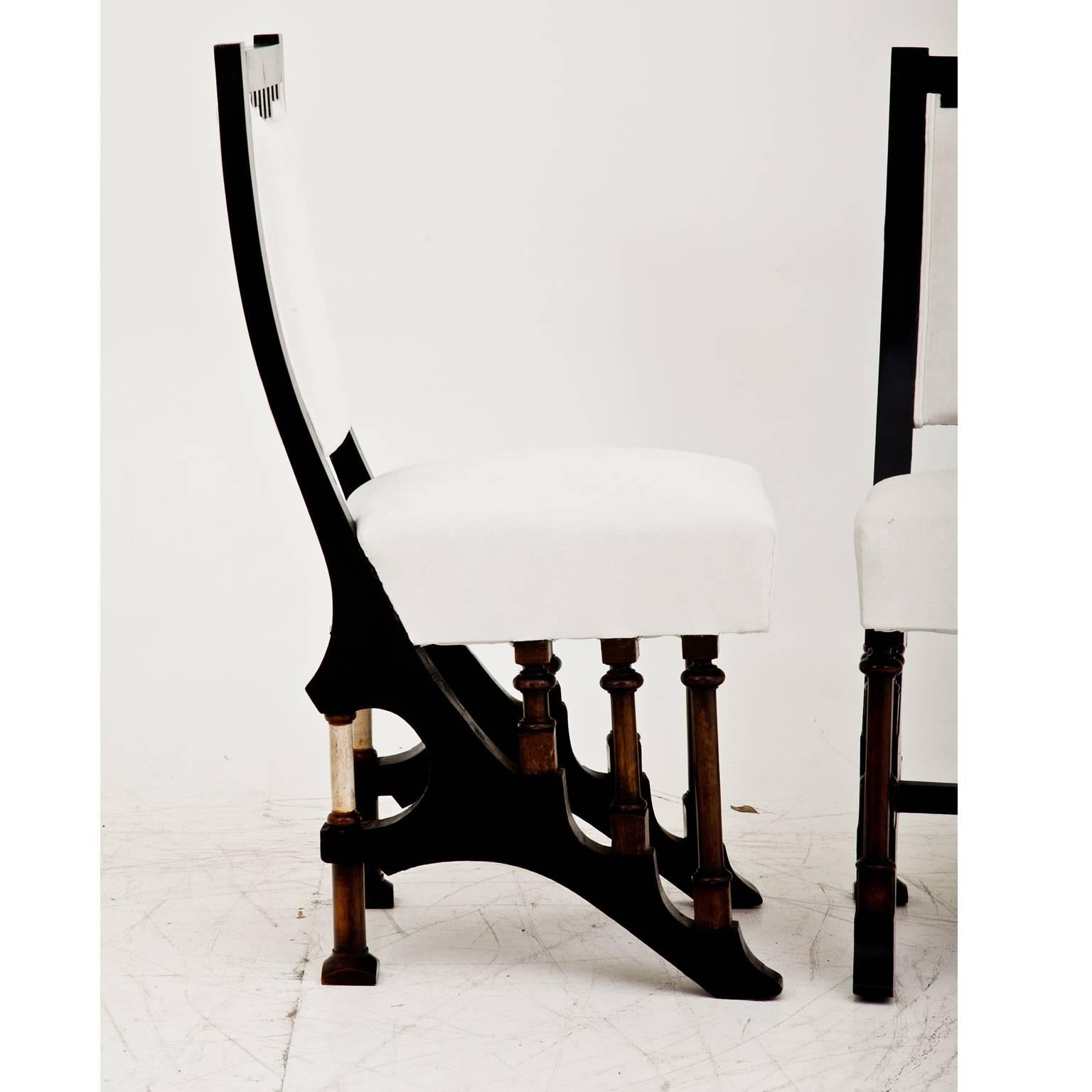 Pair of dining room chairs in the style of Carlo Bugatti (1856-1940). Each chair has a curved backrest and stands on an absolutely unusual base. The chairs were reupholstered with a high quality fabric.