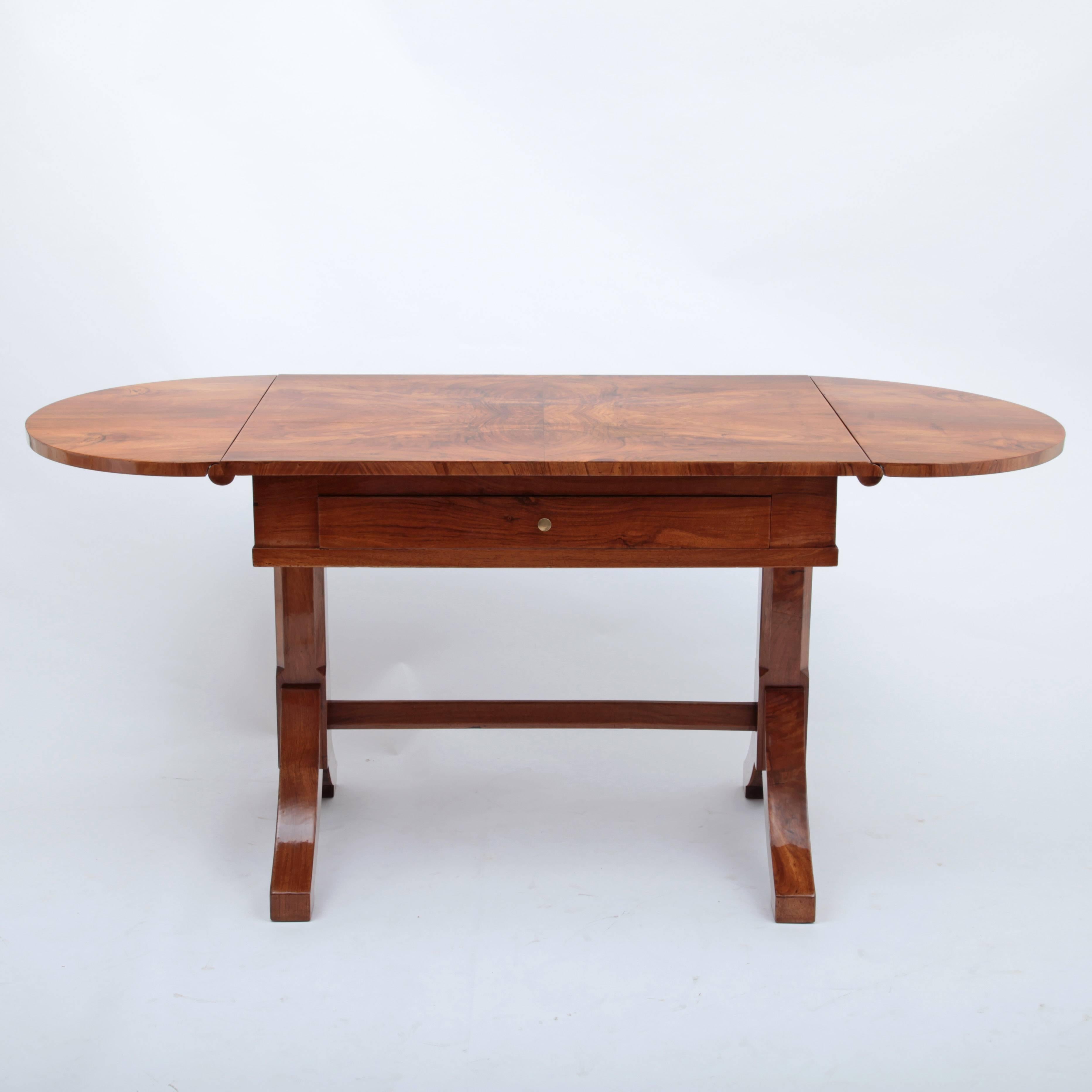 Biedermeier table with one drawer and foldable, rounded tabletop. The table has a beautiful veneer pattern.