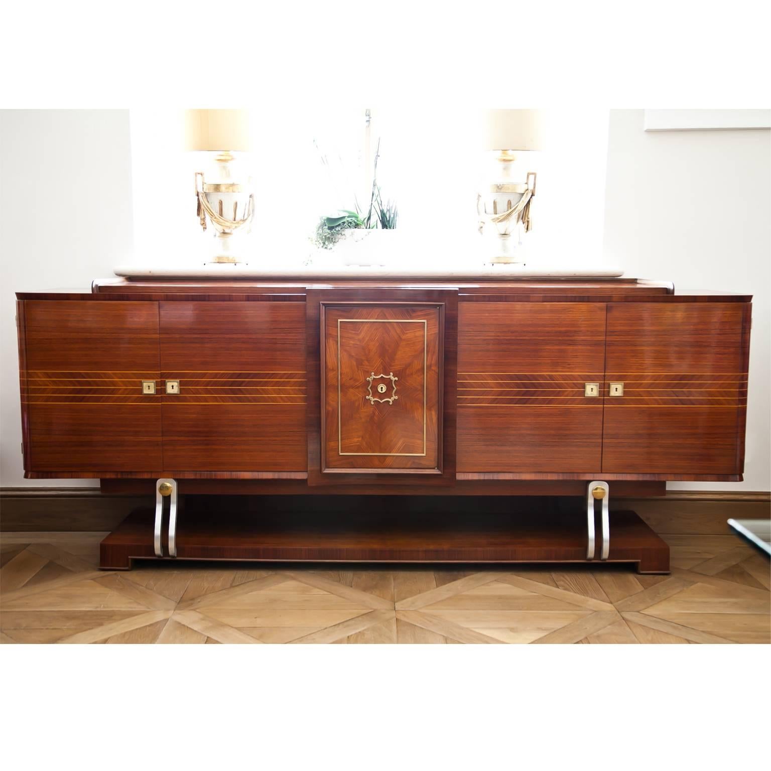 Long Art Deco sideboard on an unusual base, the tabletop is slightly raised. The front shows beautiful a star-shaped veneer pattern and thread inlays. Behind the central door is a small bar cabinet.
