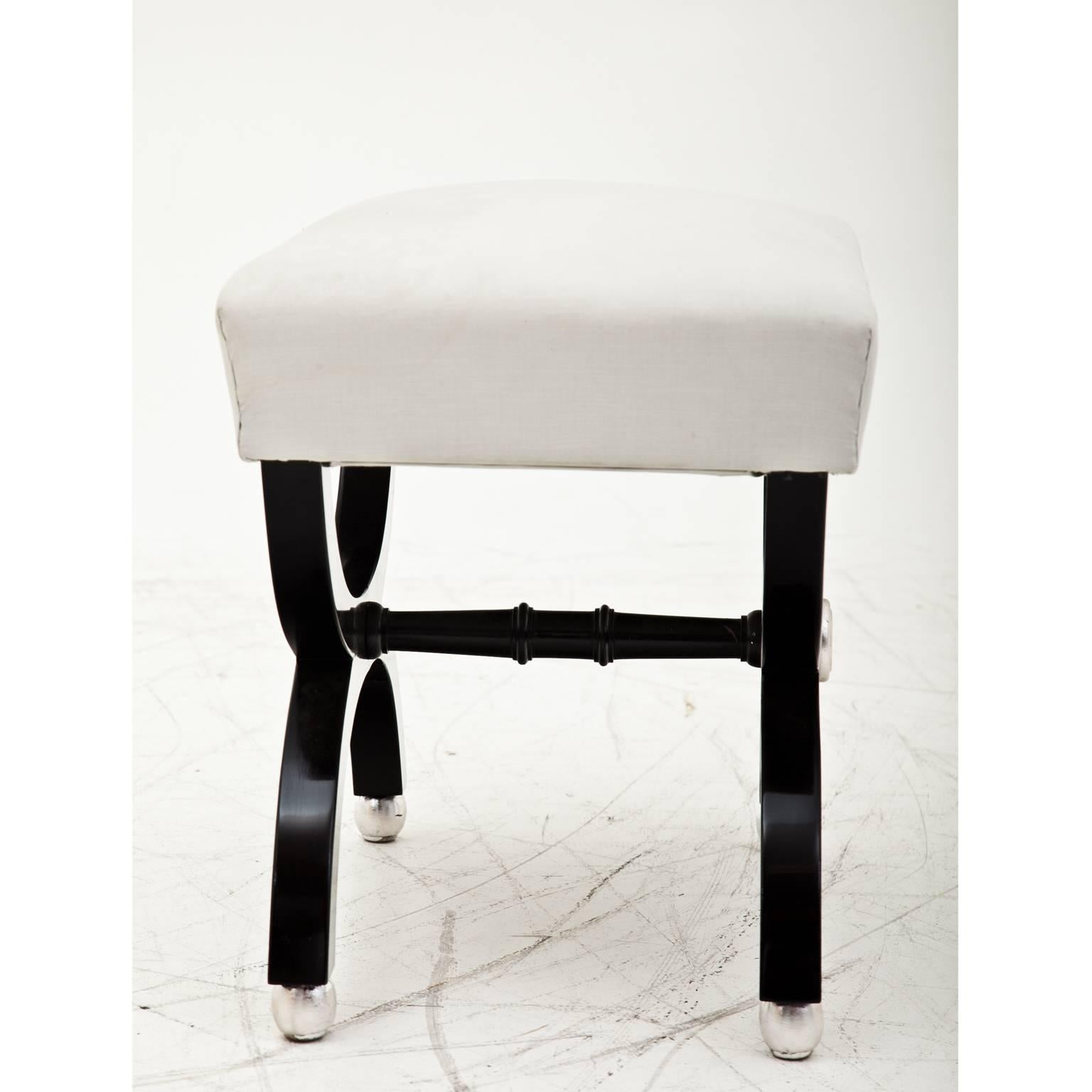 Small French tabouret on an ebonized base with turned stretchers and silvered details.