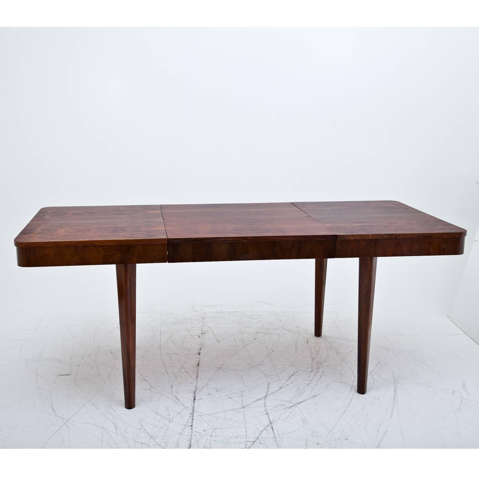 Extendable Art Deco dining room table with rounded corners, on conical legs with a beautiful veneer pattern. The extended table is 190cm wide.