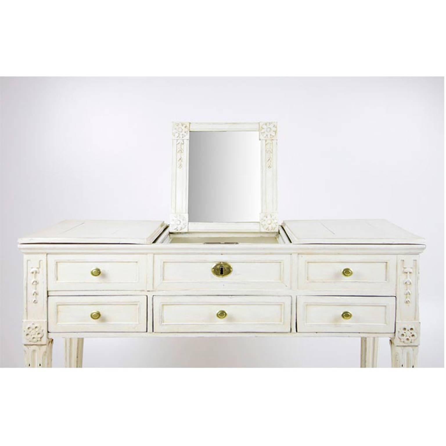 Lovely German Louis XVI vanity table or Poudreuse on fluted tapered legs. The middle section has a foldable mirror and plenty of storage space.
The white color is restored.