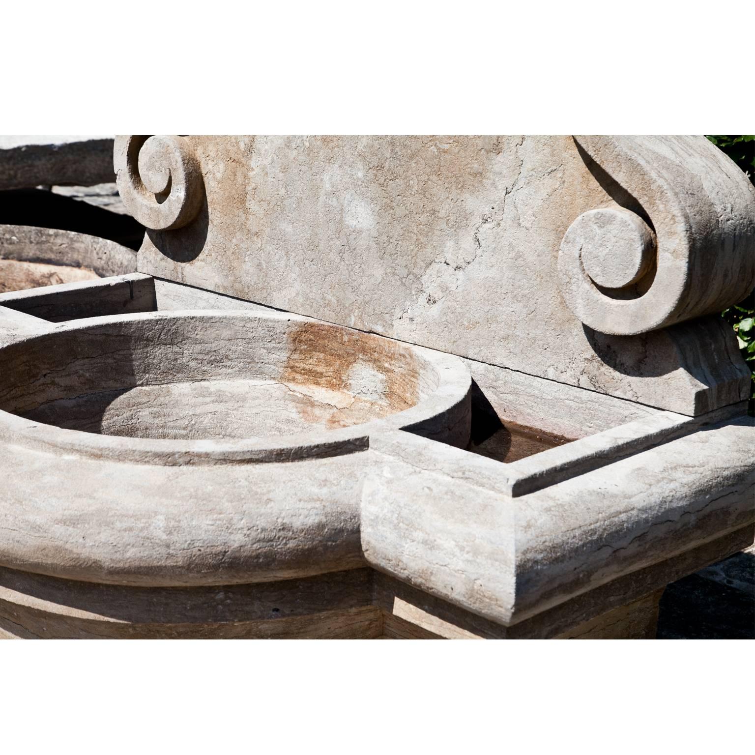 Ochre colored wall fountain out of hand-cut bluestone with a round basin and a flower ornament around the spout.
Height of the basin: 75 cm.