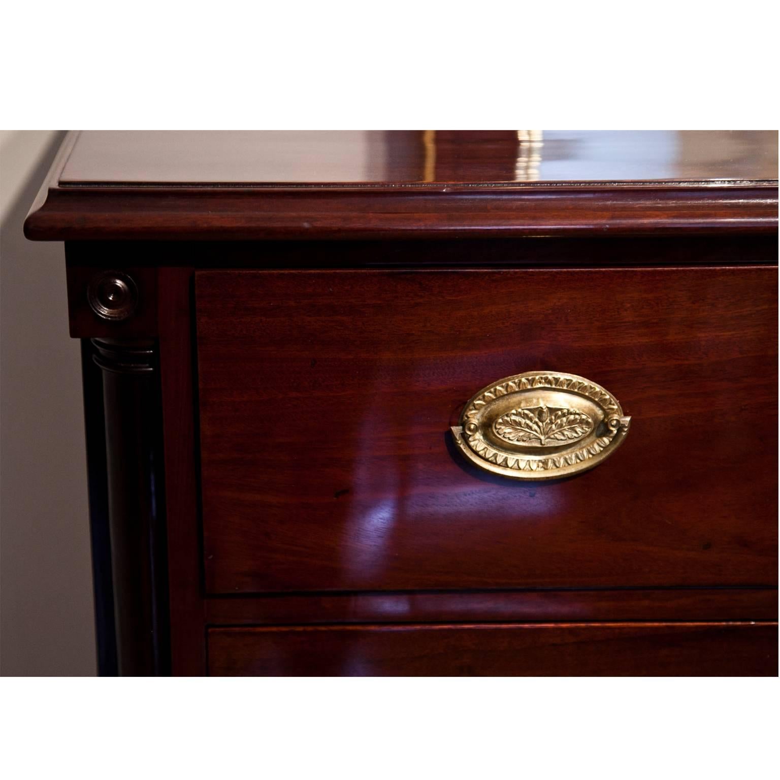 Mahogany chest of drawers on tapered feet with four drawers and brass fittings. The streamlined body with quarter columns at the corners.