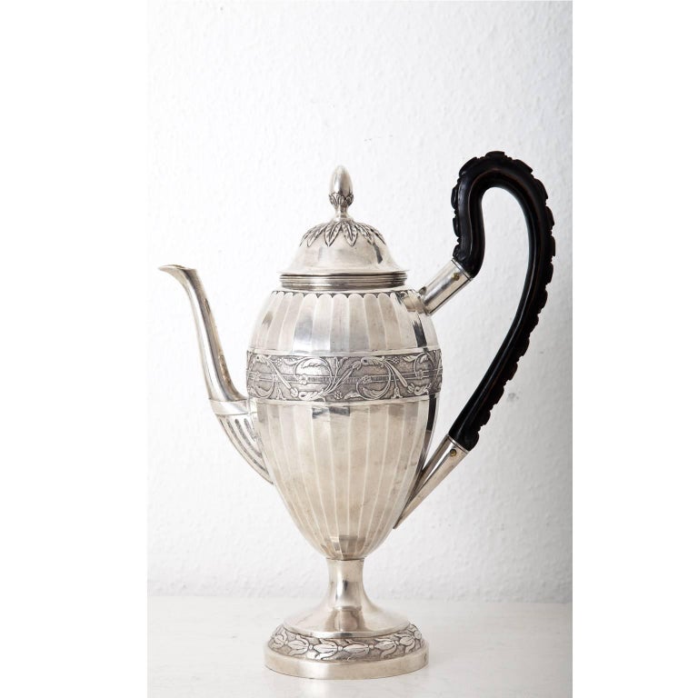 Coffee pot by Johann Jakob Hermann Grabe (1749-1833), Hallmark for Augsburg 1807-1809 and Maker's Mark IG. Lid with nut shaped Nodus, the wall with vine ornaments and a carved wooden handle. Weight: 855 g.
Seling Nr. 2581.