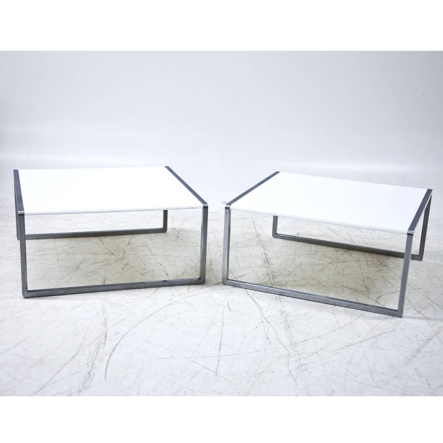 Pair of coffee tables with a white surface and metal feet.