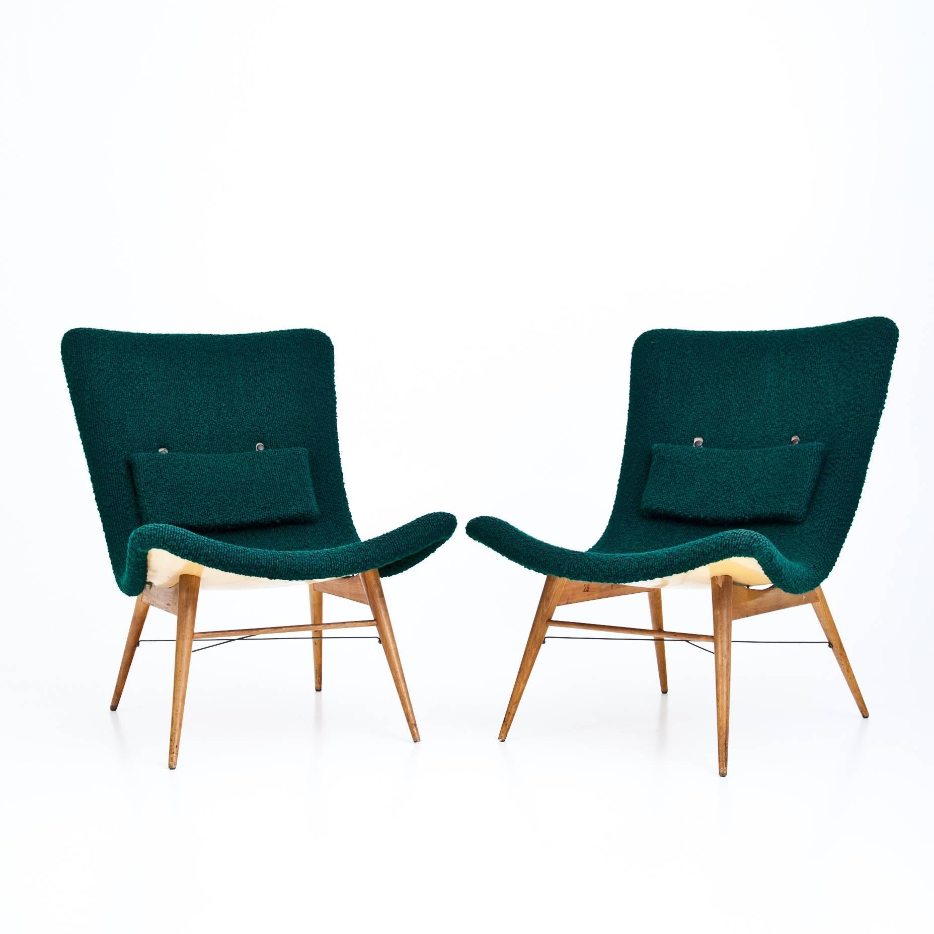 Pair of Czechoslovakian lounge chairs designed by Miroslav Navrátil for Ceský Nábytek. The chairs stand on flared, conical legs with crossed wire strutting, green upholstered seat and a light yellow back. The chairs are numbered K33848 and K33849
