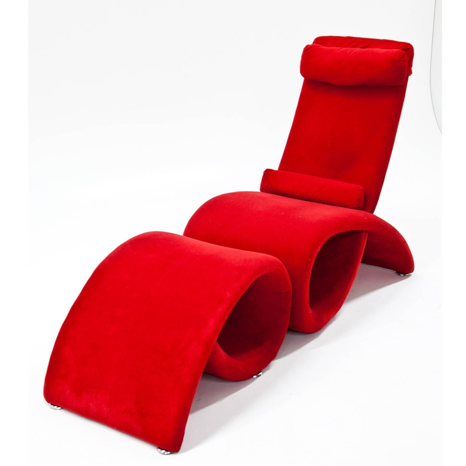 Two-part lounge chair with footstool in an unusual curved shape. Chair and footrest are upholstered with a red velour fabric.