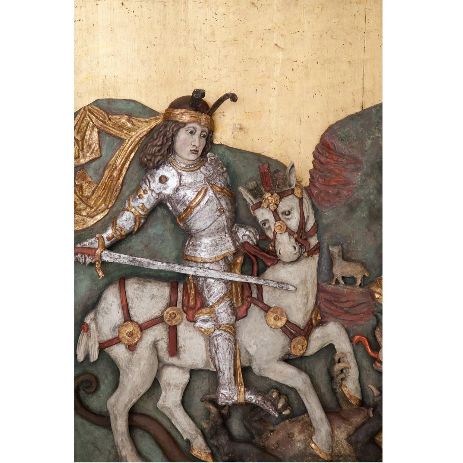 Large poylchrome relief depicting Saint George on his horse, slaying the dragon. In the background on the right is the benefactress. The back panel is probably from the 1950s. 
Size without frame: 122 x 100 cm.