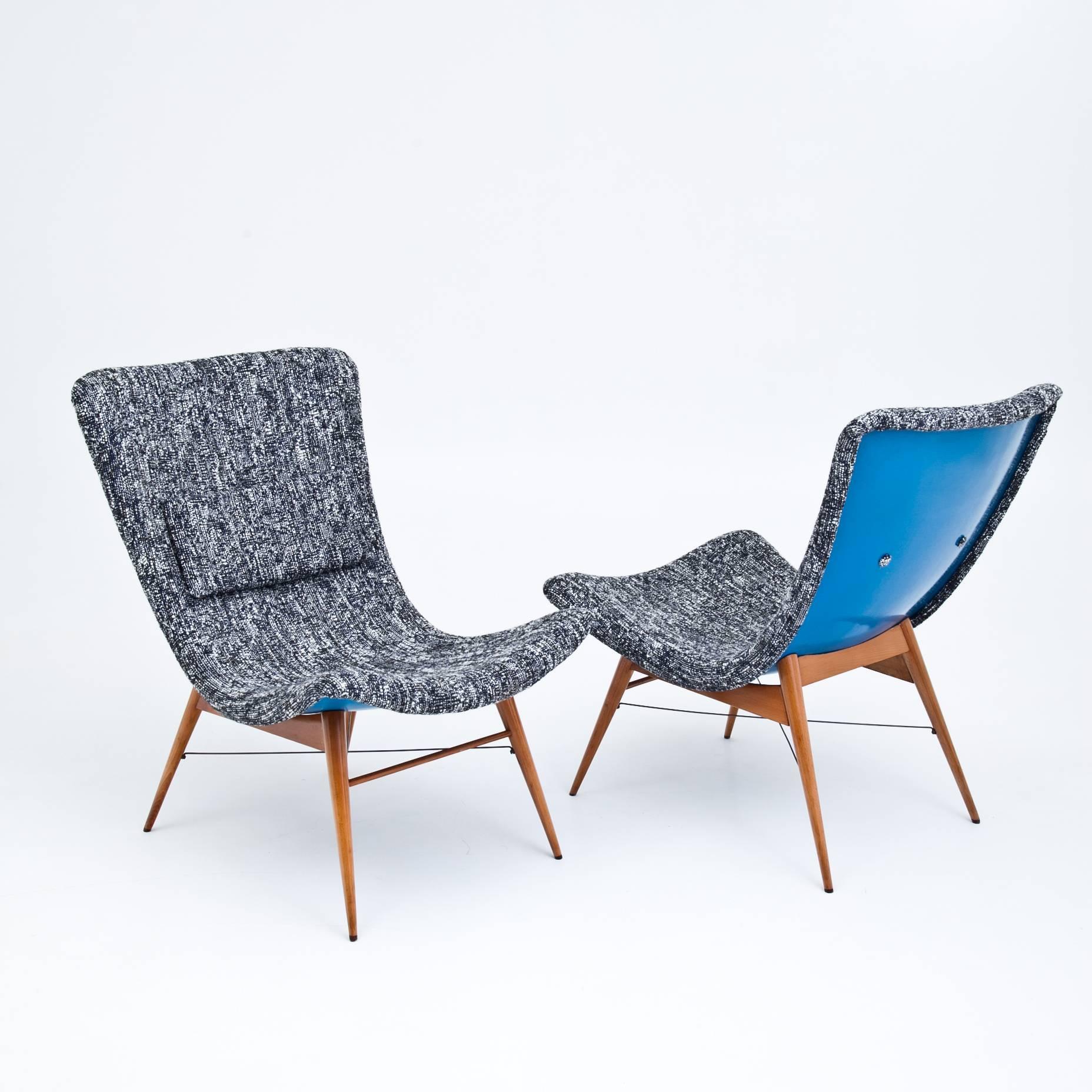 Pair of Czechoslovakian lounge chairs designed by Miroslav Navrátil for Ceský Nábytek. The chairs stand on flared, conical legs with crossed wire strutting. The seats are upholstered with a new blueish-grey fabric and have a blue underside. The