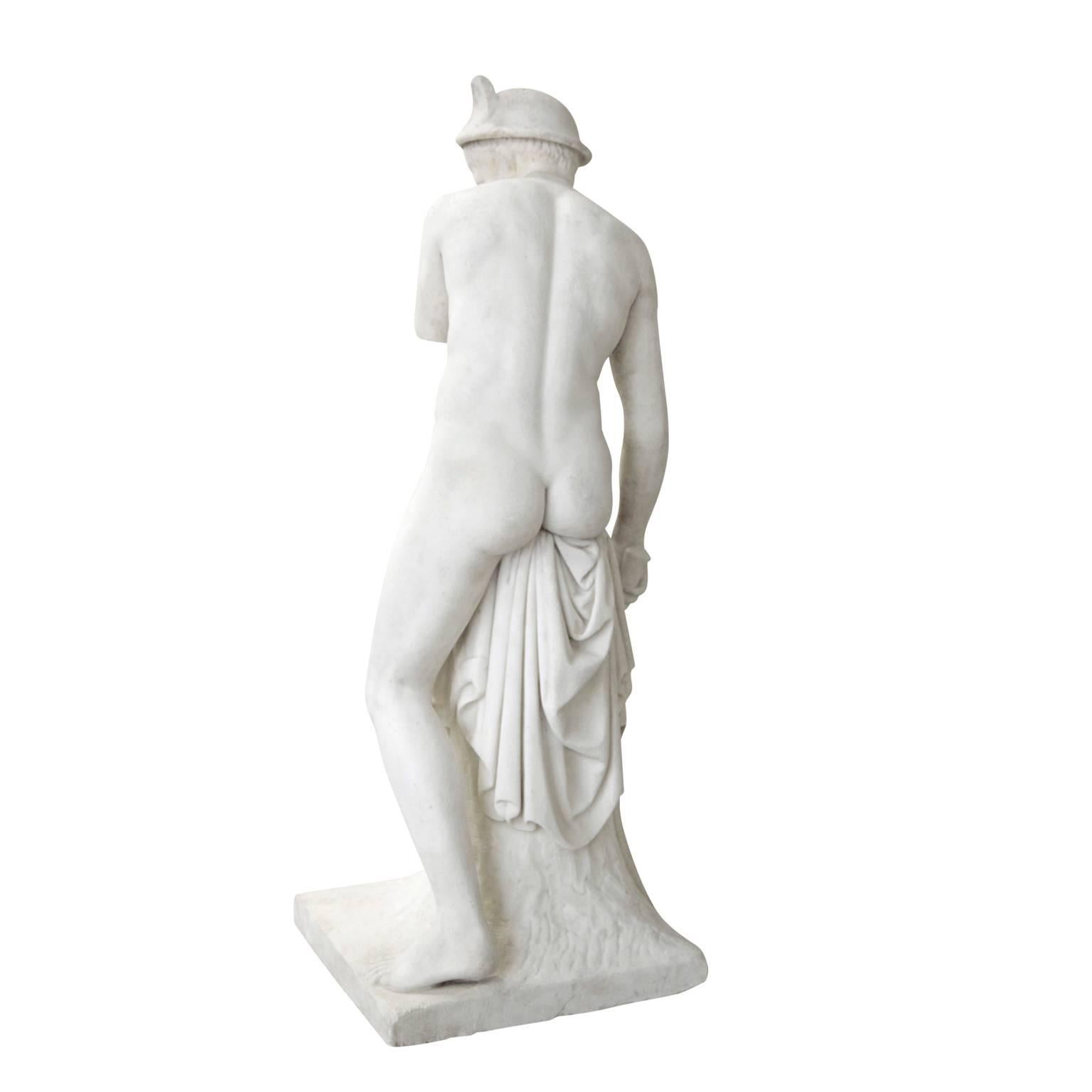 Marble sculpture of Hermes, early 19th century.
The naked Hermes sits on a tree stump over which he has thrown some sort of cloth. His left leg supports himself while the right leg is swung over the stump. His right foot is missing. His upper body