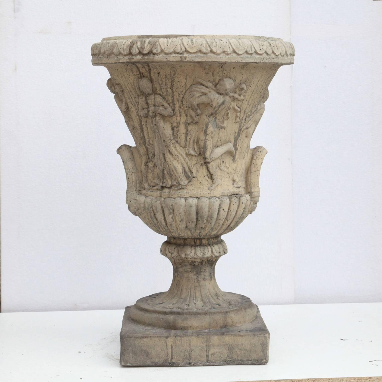 An Amphora with a depiction of an allegory. This planter is available in various colors including antique grey, antique white, sandstone and teracotta.