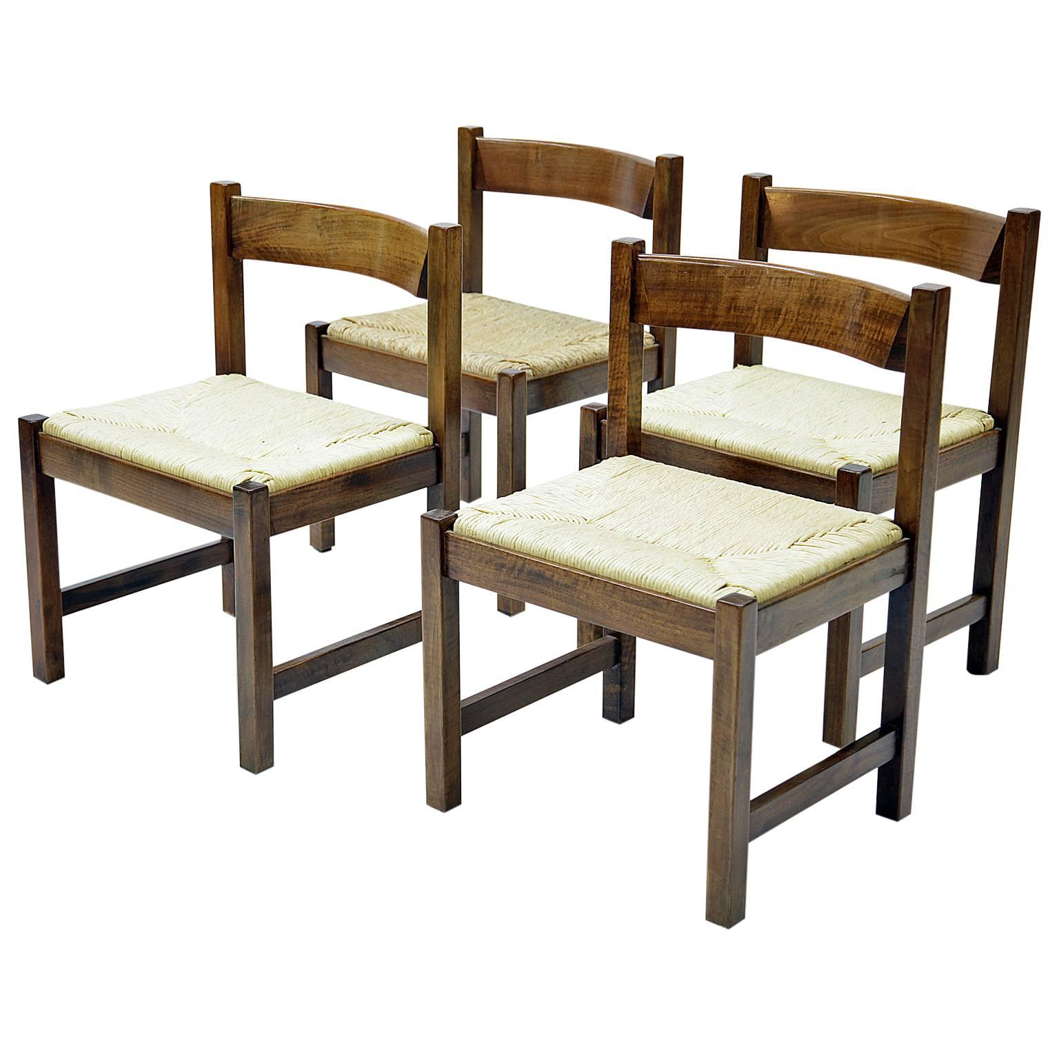 This dining room ensemble by Giovanni Michelucci consists of four chairs, one bench, and a large table. Each piece expects one chair has the carved signature of G. Michelucci on the side. The table and the bench are similar designed and show a very