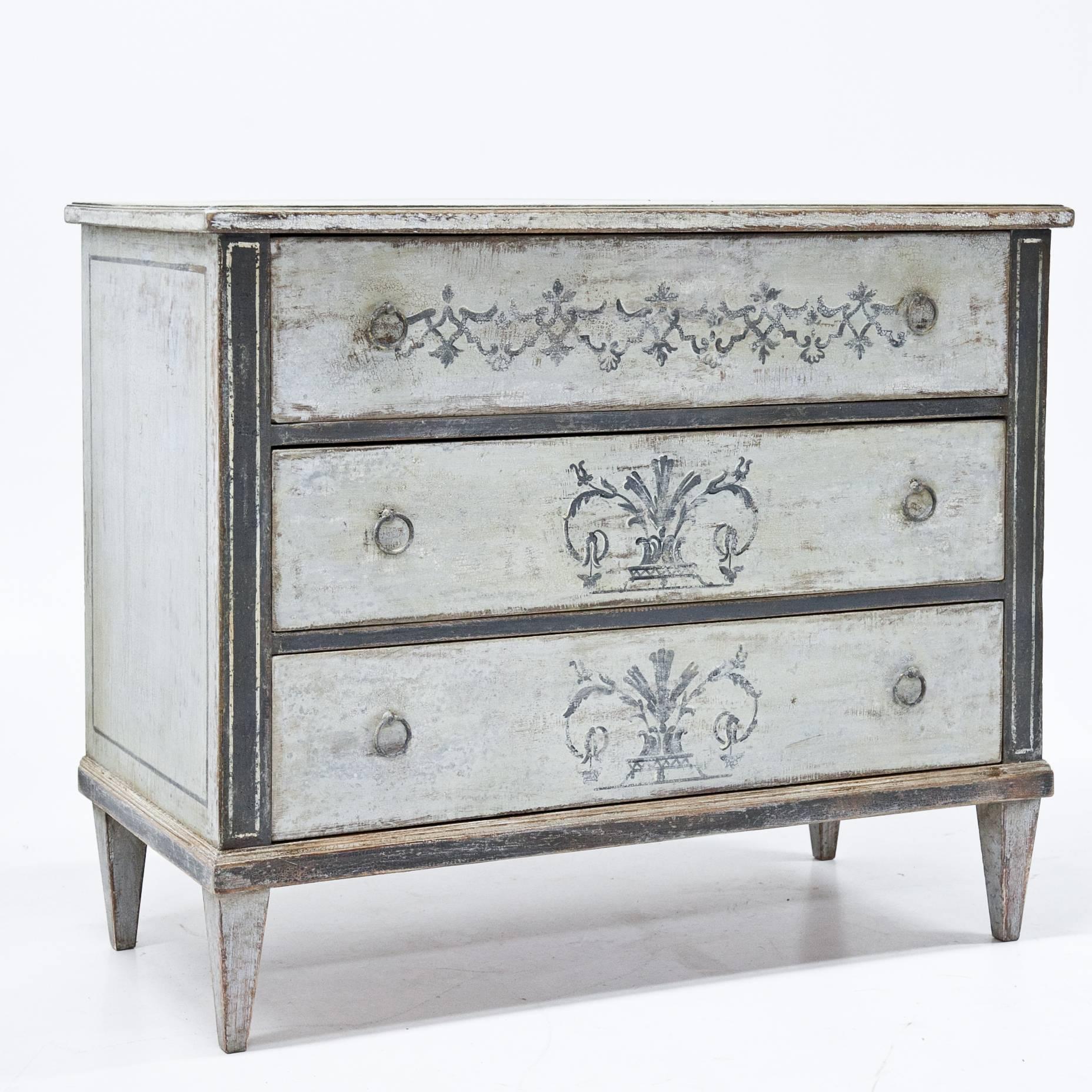 Blue Gustavian Style chest of drawers on tapered legs. The streamlined body has three drawers and a lock on the side. The pale blue paint is new and has a decorative worn look to it.