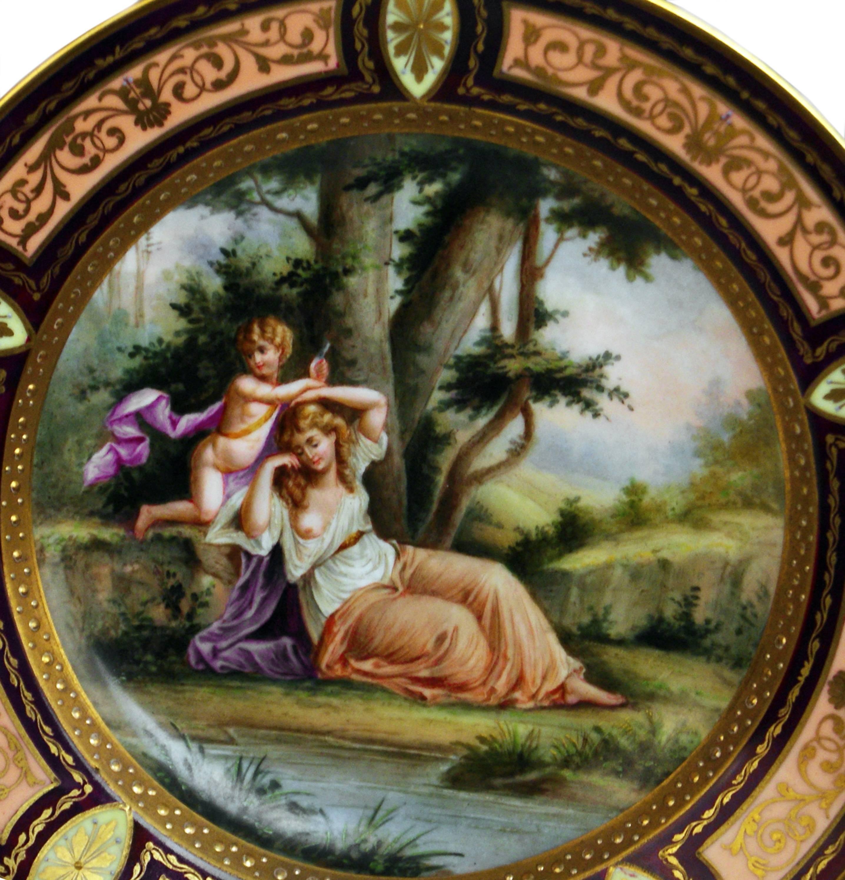 Stunning picture plate with figurines of Royal Vienna Porcelain Manufactory:
Finest quality / edged areas are decorated with so-said Grotesque
(Italian: Grotteschi) pattern laid on purple red and rose red ground and painted
in golden color.